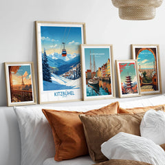 Kitzbuhel Wall Art Print in a gallery wall set of five framed travel prints in natural wood frames above a bed