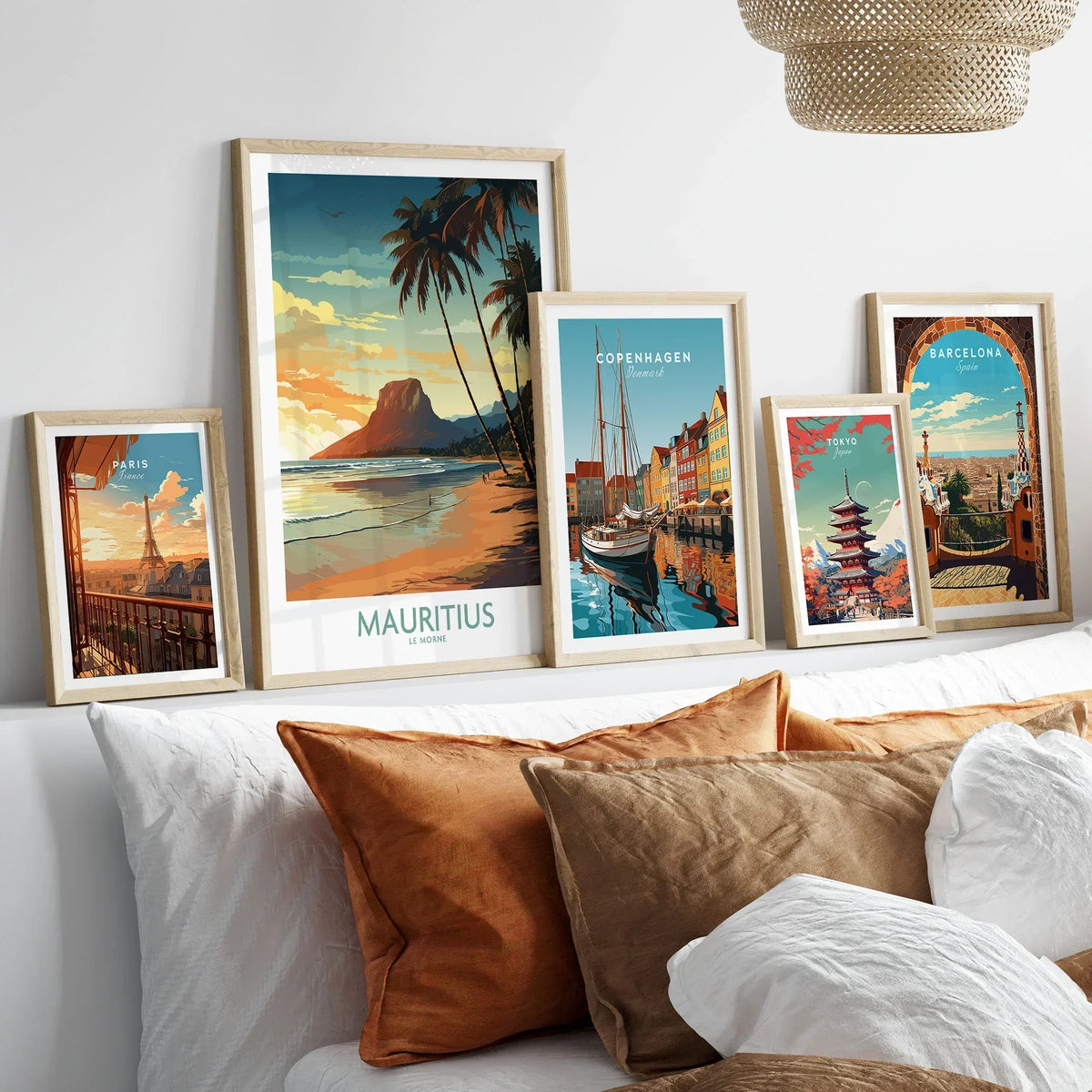 Mauritius Le Morne Print in a gallery wall set of five framed travel prints in natural wood frames above a bed