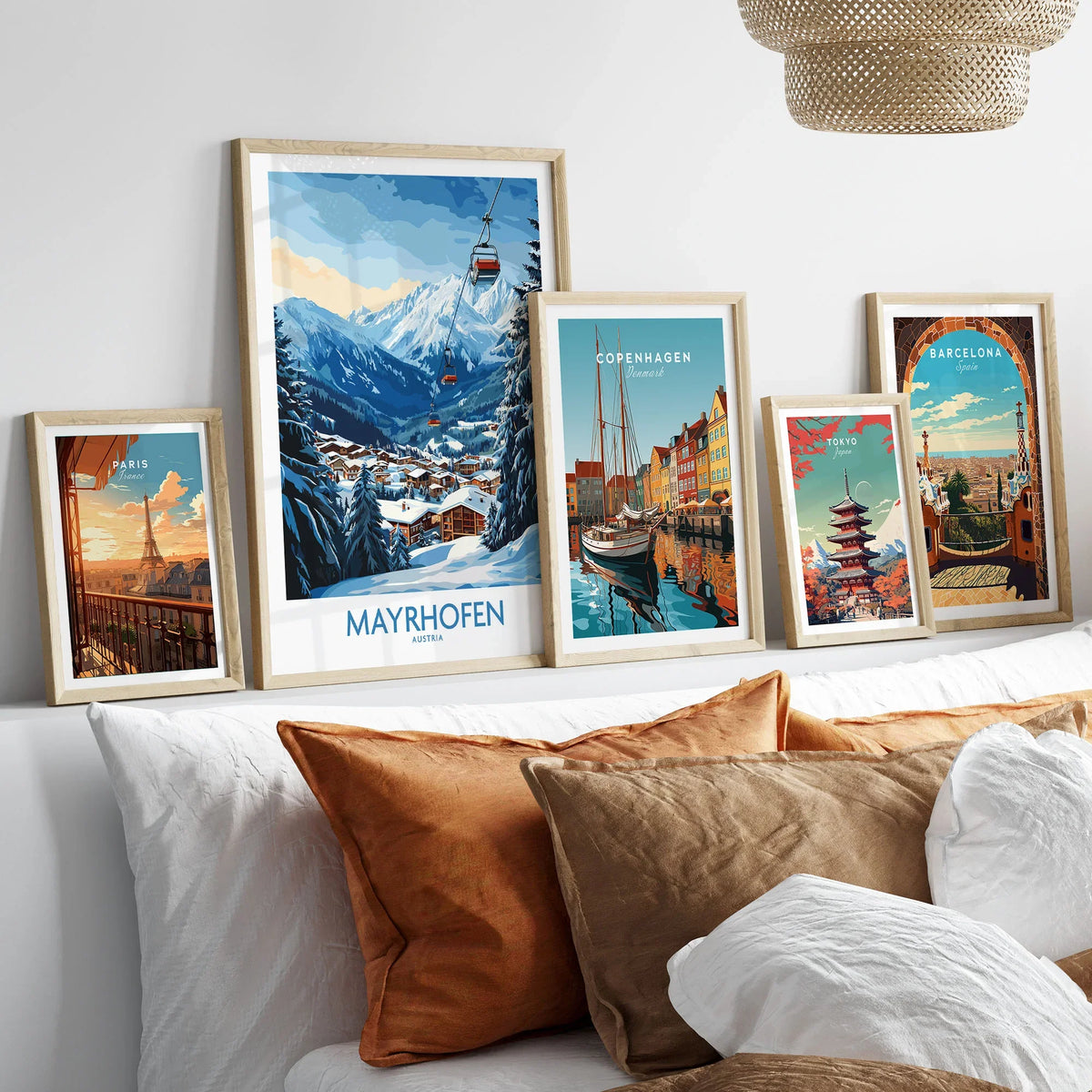 Mayrhofen Ski Poster in a gallery wall set of five framed travel prints in natural wood frames above a bed