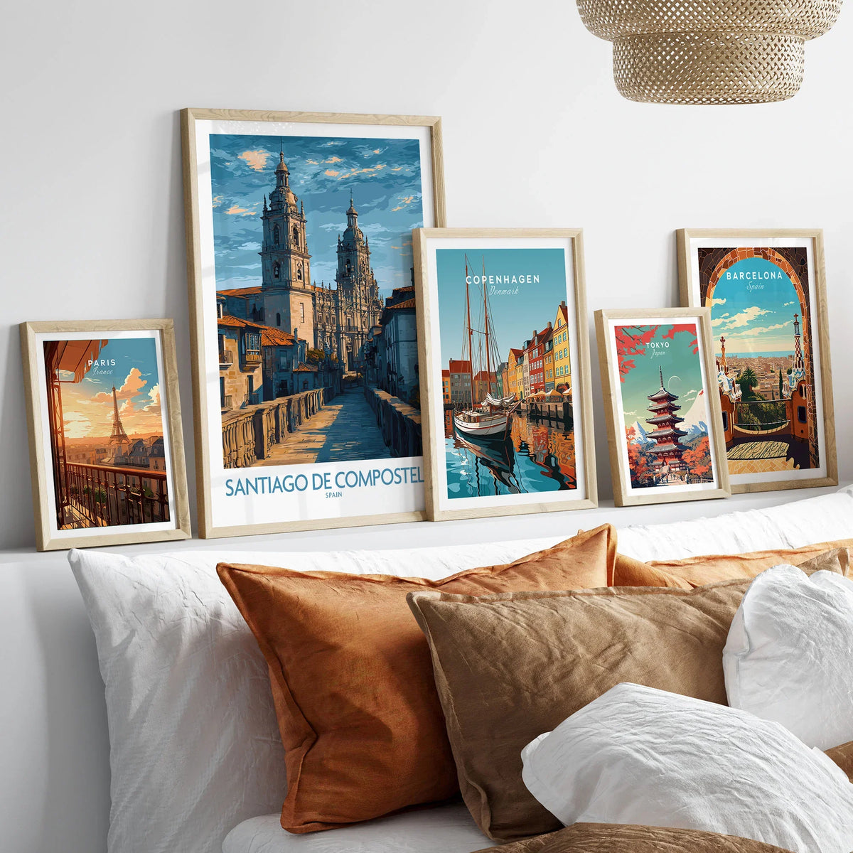 Santiago de Compostela Art Print | Galician Travel Poster in a gallery wall set of five framed travel prints in natural wood frames above a bed