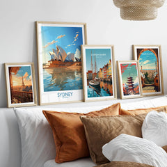 Sydney Print in a gallery wall set of five framed travel prints in natural wood frames above a bed