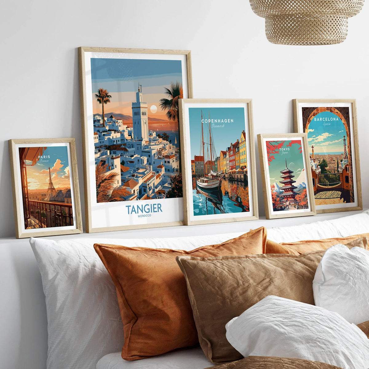 Tangier Morocco Sailboats and Rooftops Wall Art — Tangier medina rooftops and a minaret above a bay dotted with sails, shown as set five framed artprints above bed natural wood frames