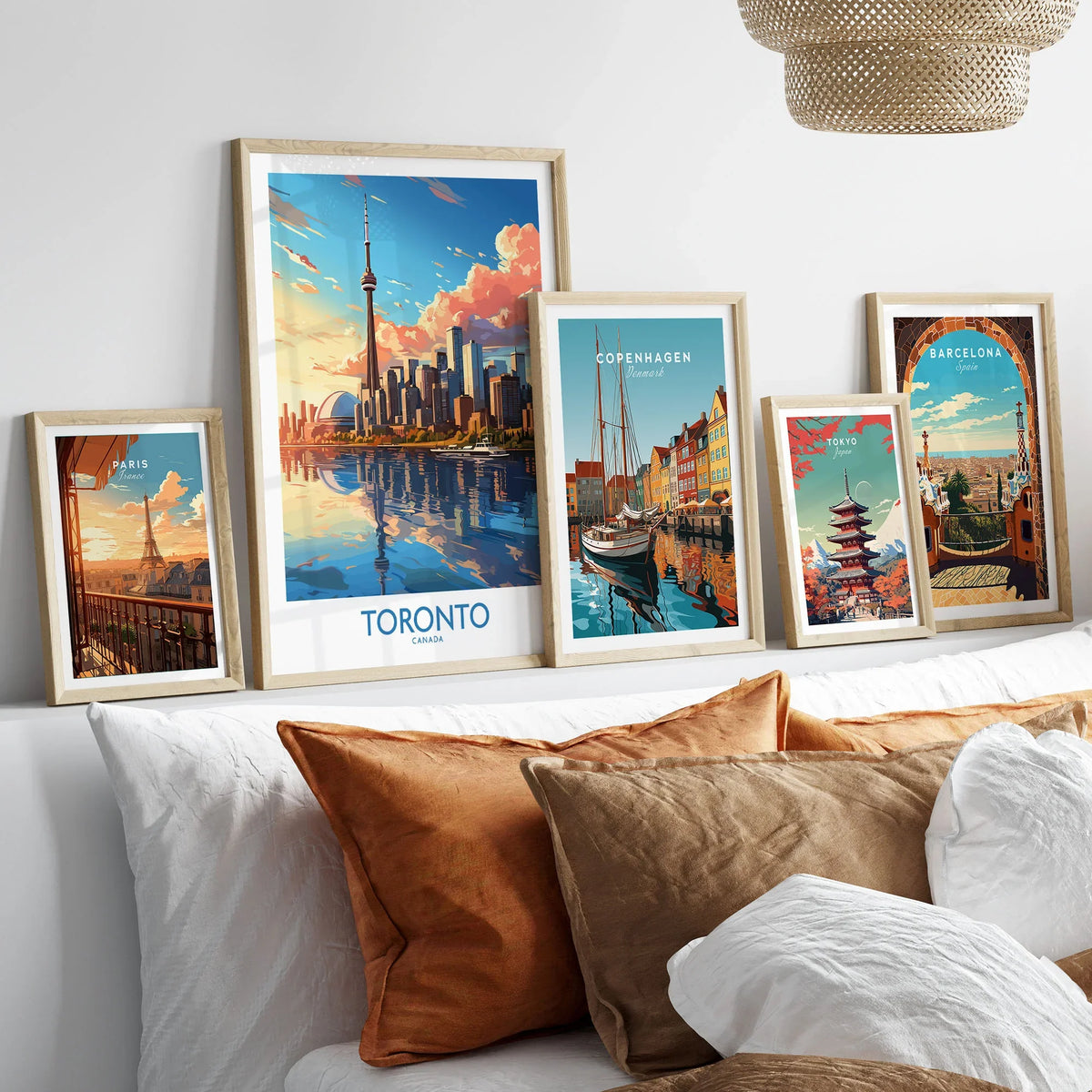 Toronto Wall Art Print in a gallery wall set of five framed travel prints in natural wood frames above a bed