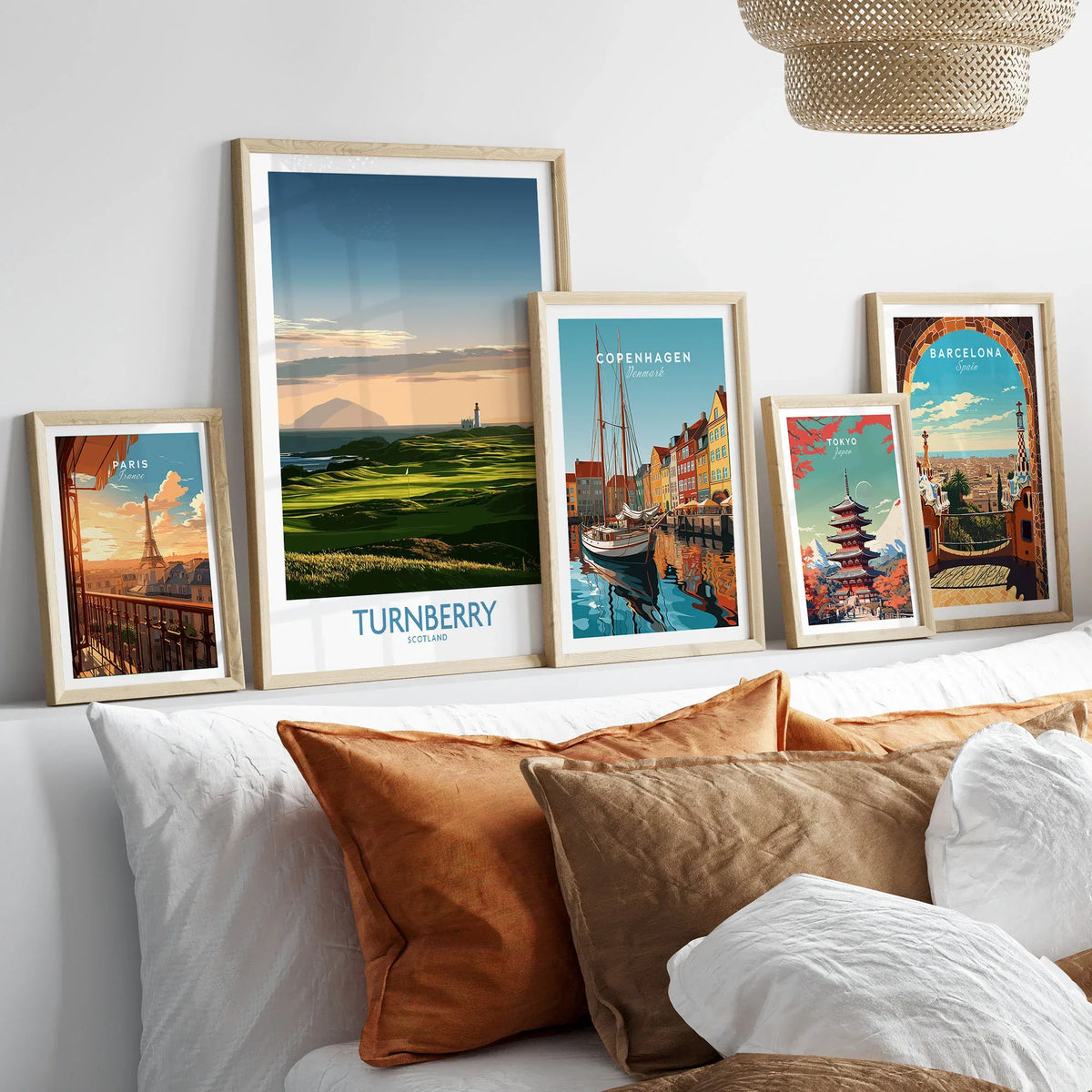 Turnberry Scotland Ayrshire Dusk Wall Art — Ailsa Craig and the white lighthouse across rolling coastal turf at dusk, shown as set five framed artprints above bed natural wood frames