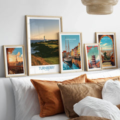 Turnberry Scotland Rocky Shore Wall Art — the Turnberry lighthouse above a rocky shore with the Arran hills beyond, shown as set five framed artprints above bed natural wood frames
