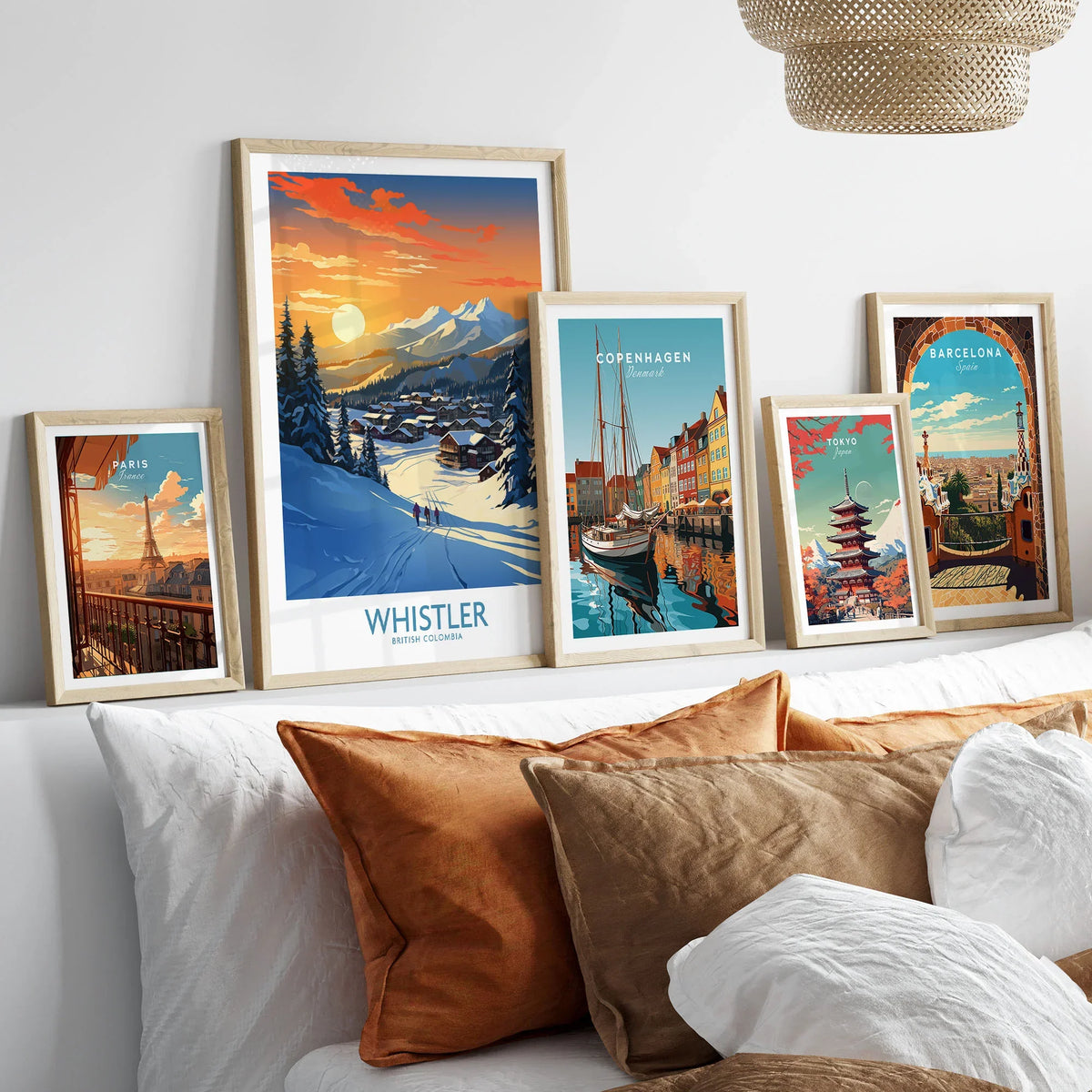 Whistler Wall Art Ski Poster in a gallery wall set of five framed travel prints in natural wood frames above a bed
