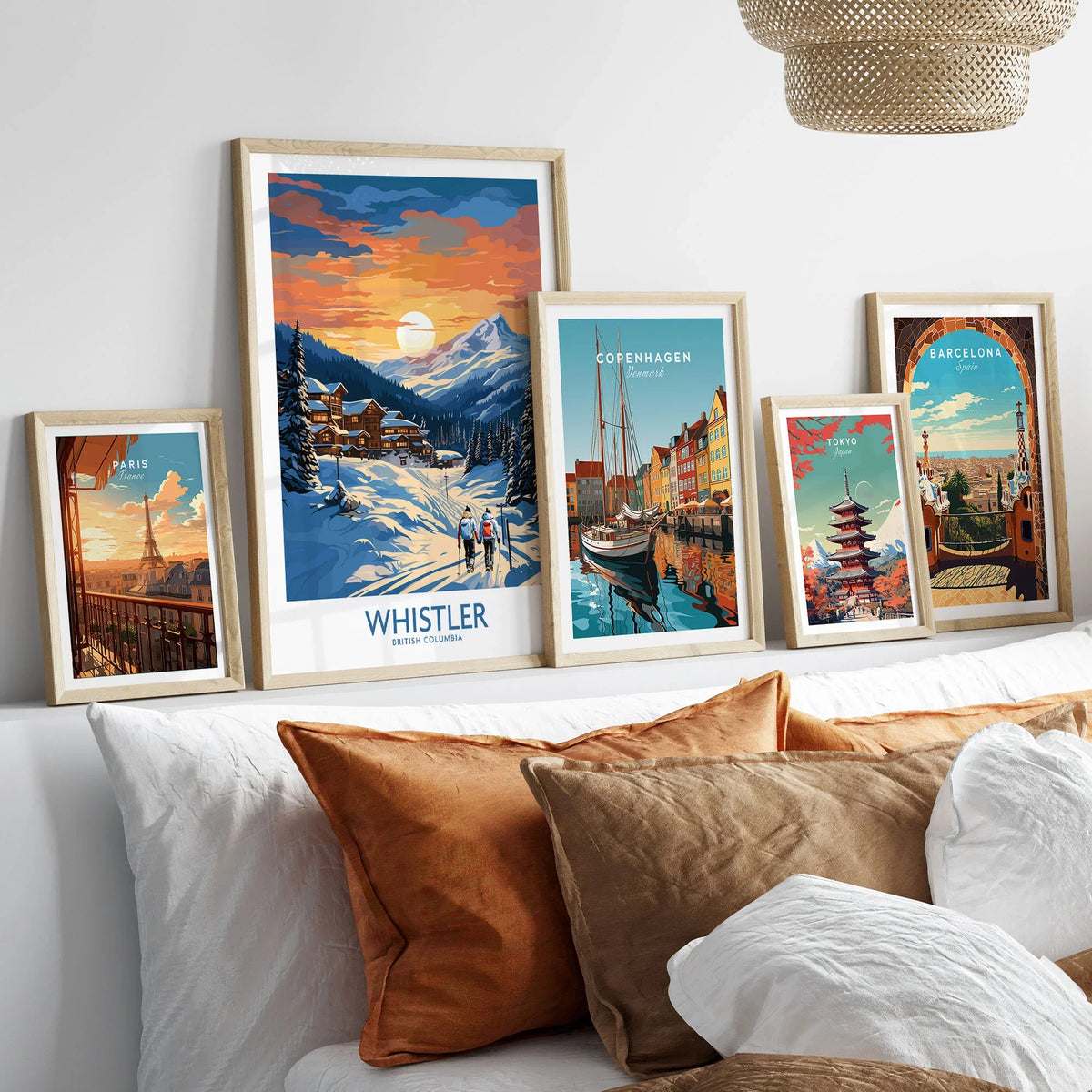 Whistler Print in a gallery wall set of five framed travel prints in natural wood frames above a bed