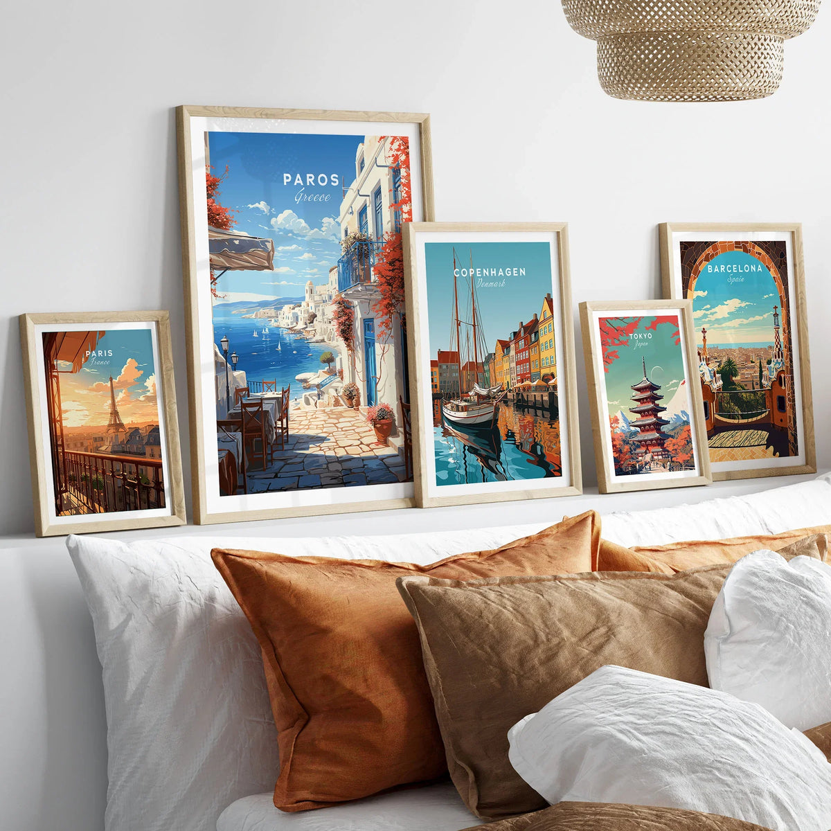 Paros Travel Poster in a gallery wall set of five framed travel prints in natural wood frames above a bed