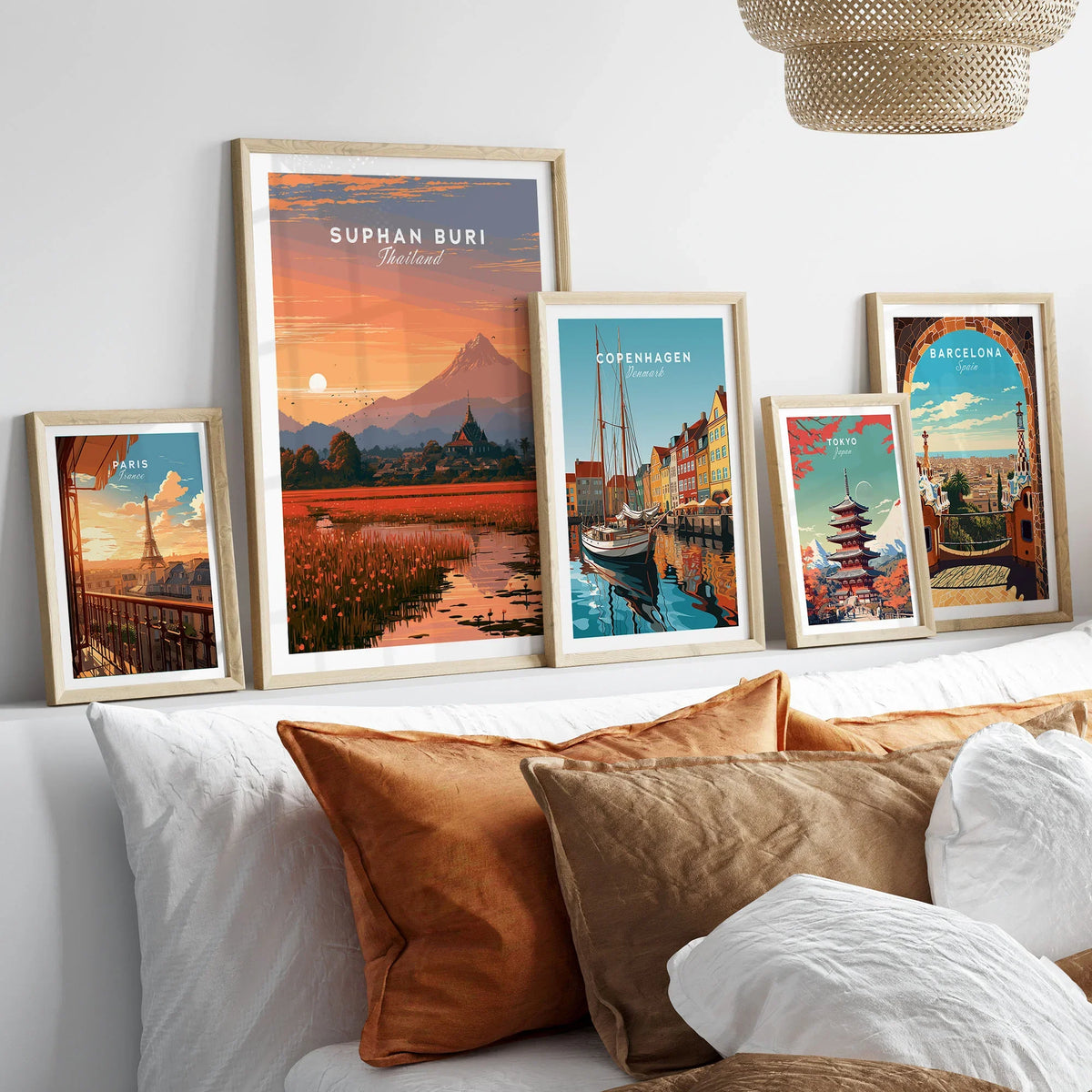 Suphan Buri Thailand Lotus Lake Travel Poster — a lotus-covered lake and temple spire at sunset beneath a mountain peak, shown as set five framed artprints above bed natural wood frames