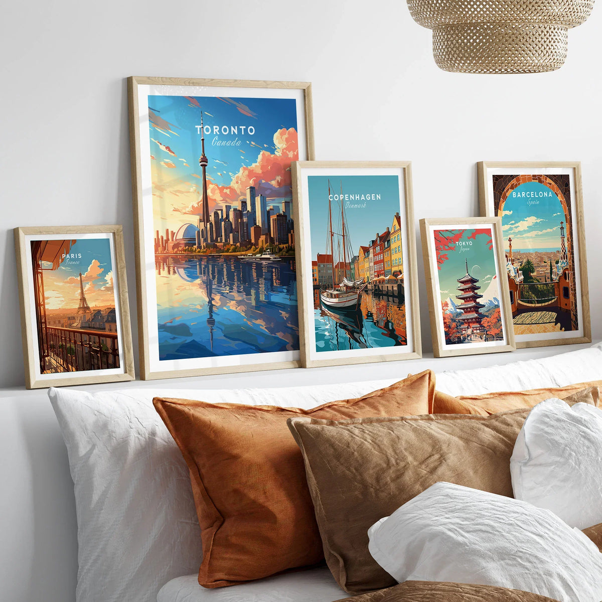 Toronto Poster in a gallery wall set of five framed travel prints in natural wood frames above a bed