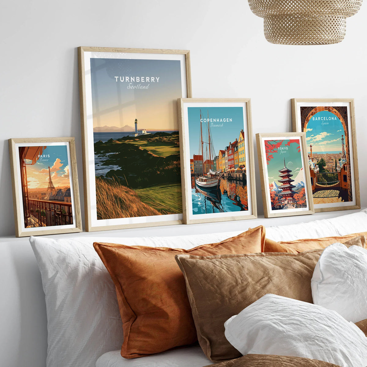 Turnberry Scotland Lighthouse Travel Poster — the Turnberry lighthouse above a rocky shore with the Arran hills beyond, shown as set five framed artprints above bed natural wood frames