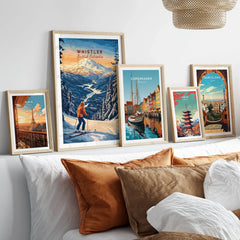 Whistler Travel Poster -  British Columbia in a gallery wall set of five framed travel prints in natural wood frames above a bed