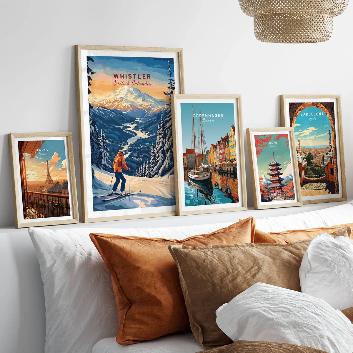 Whistler Travel Poster -  British Columbia in a gallery wall set of five framed travel prints in natural wood frames above a bed