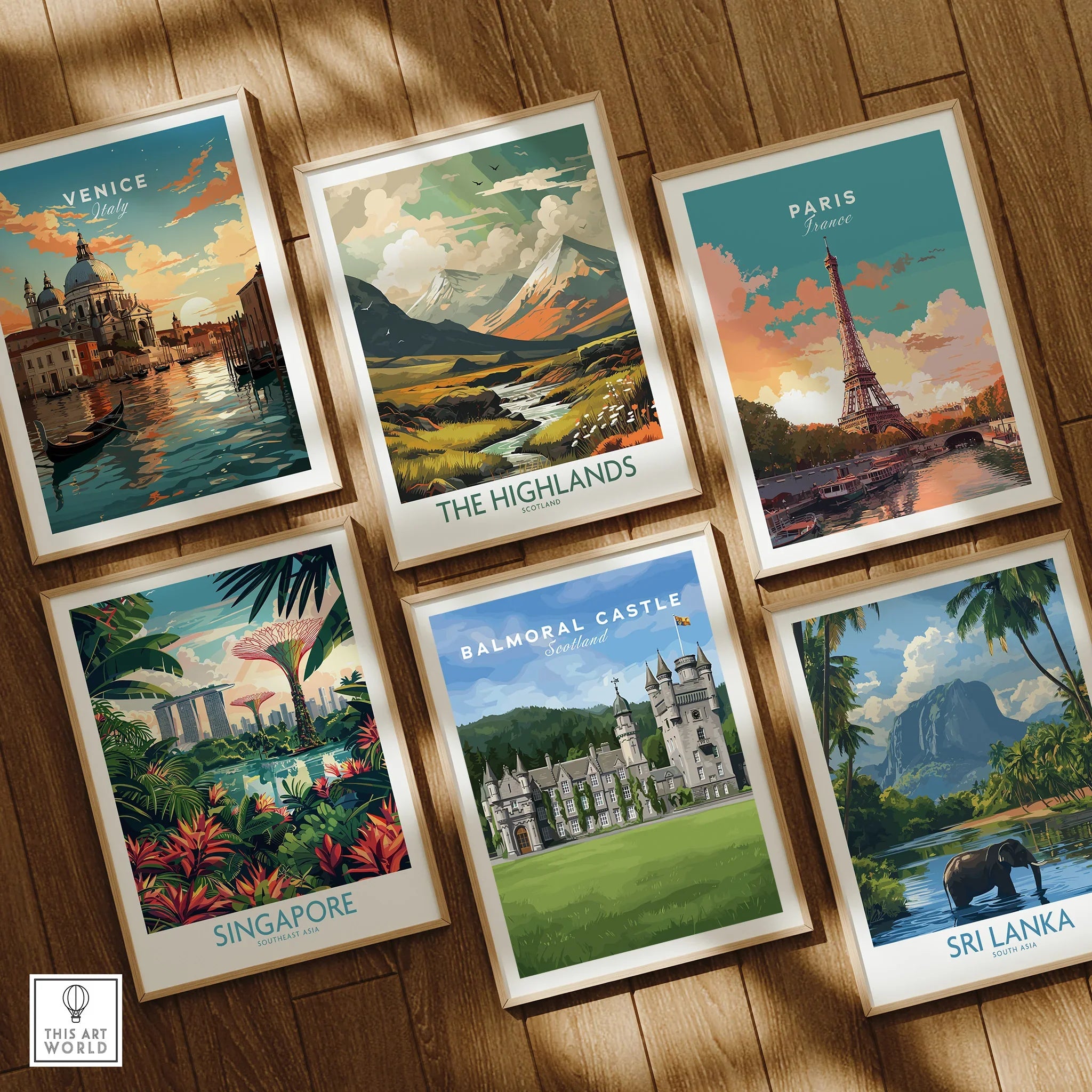 Set of six framed travel art prints on wooden floor, featuring Venice, Paris, Highlands, Singapore, Balmoral Castle, and Sri Lanka landscape posters.