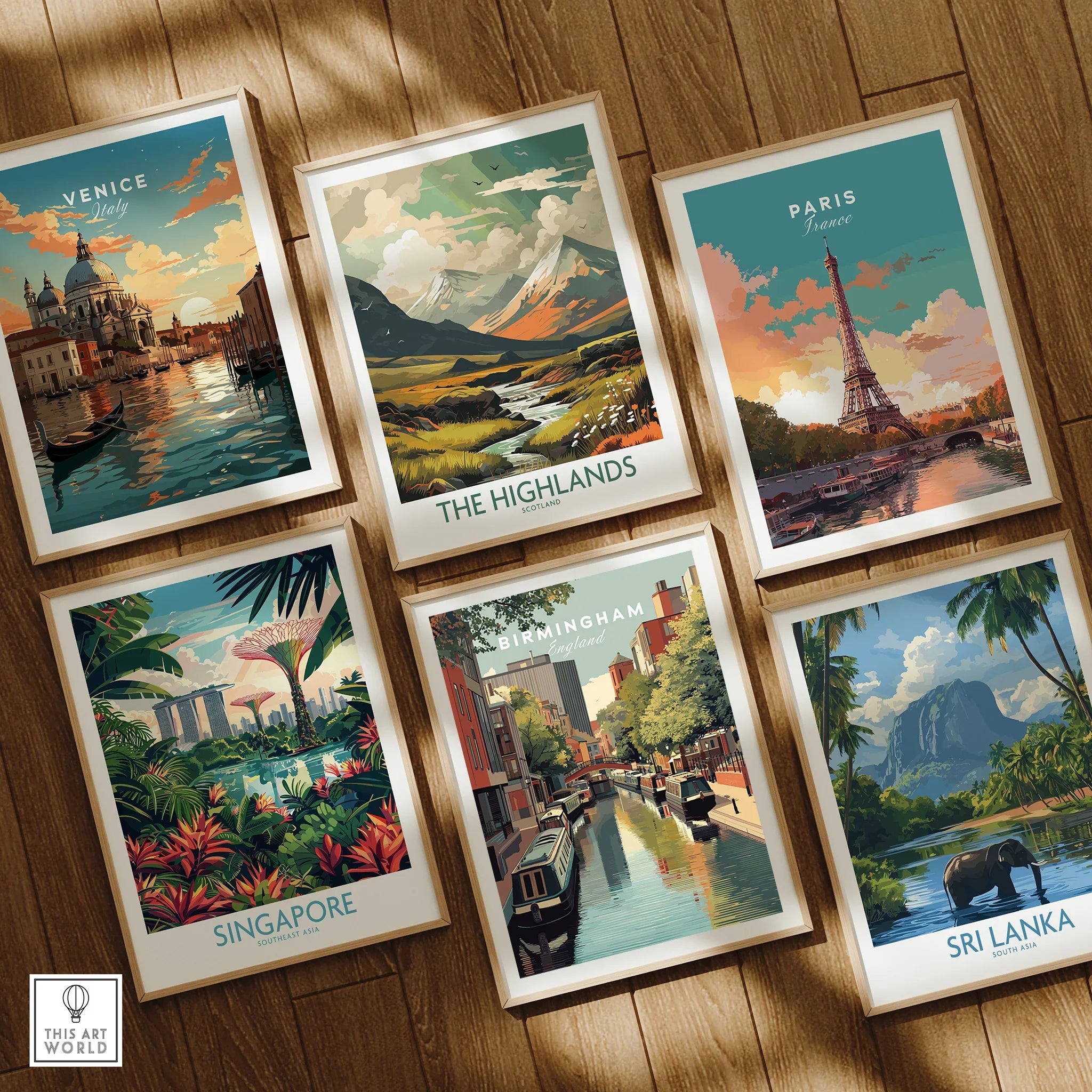Set of six framed travel poster art prints featuring Venice, the Highlands, Paris, Singapore, Birmingham, and Sri Lanka, arranged on a wooden floor.