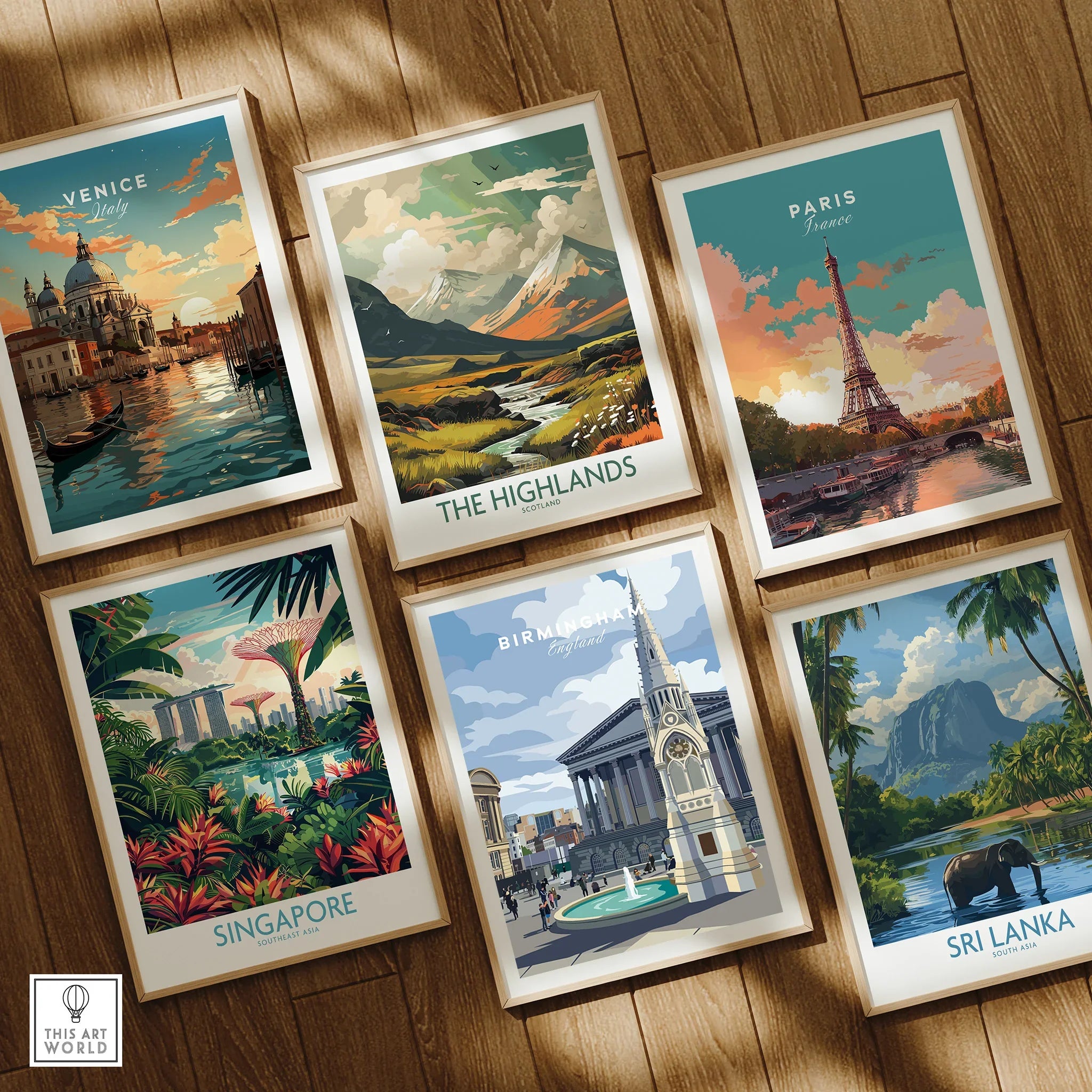 Set of six framed travel art prints featuring Venice, Paris, Highlands, Singapore, Birmingham, and Sri Lanka on a wooden floor.