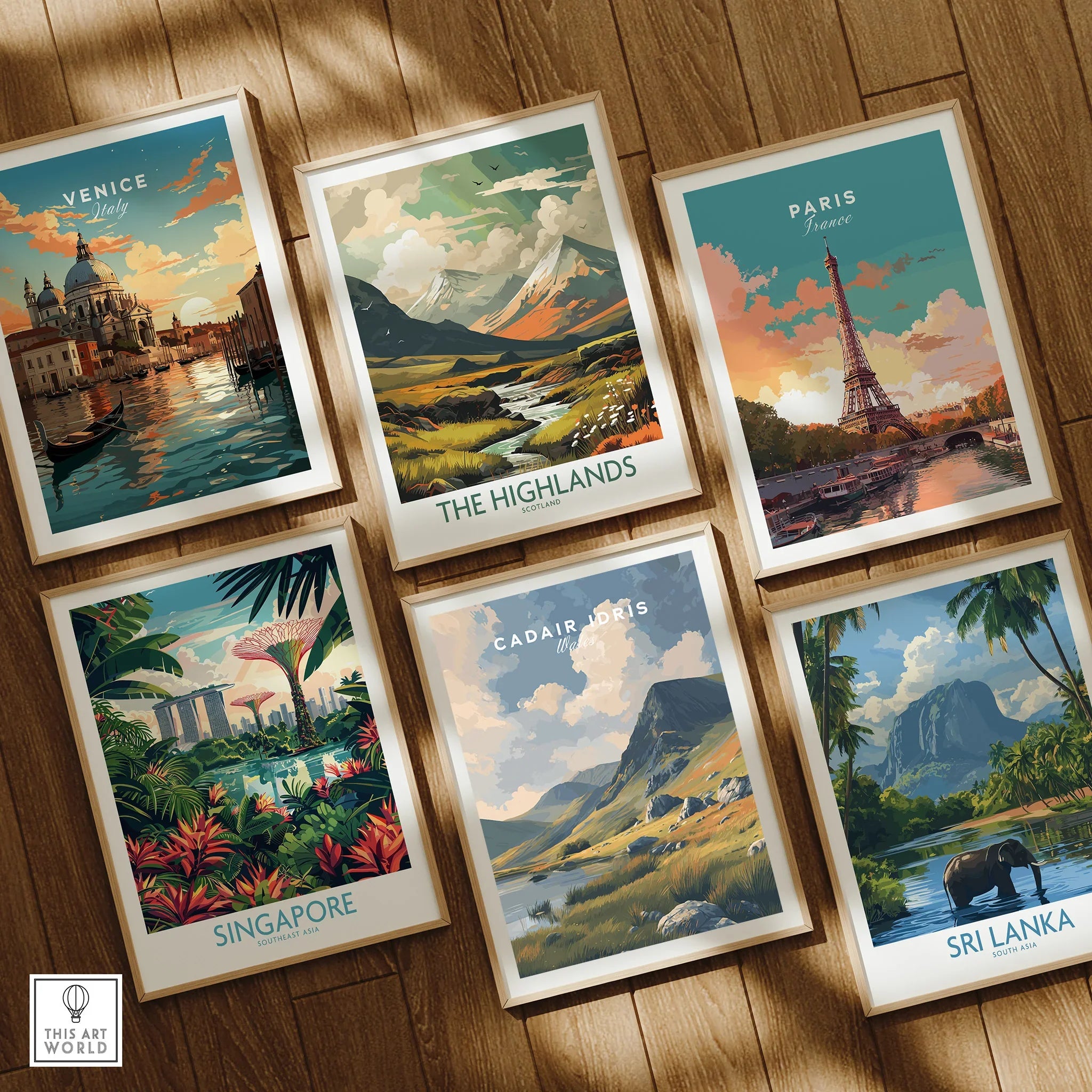 Set of six framed travel art prints featuring Venice, The Highlands, Paris, Singapore, Cadair Idris, and Sri Lanka, displayed on a wooden floor.