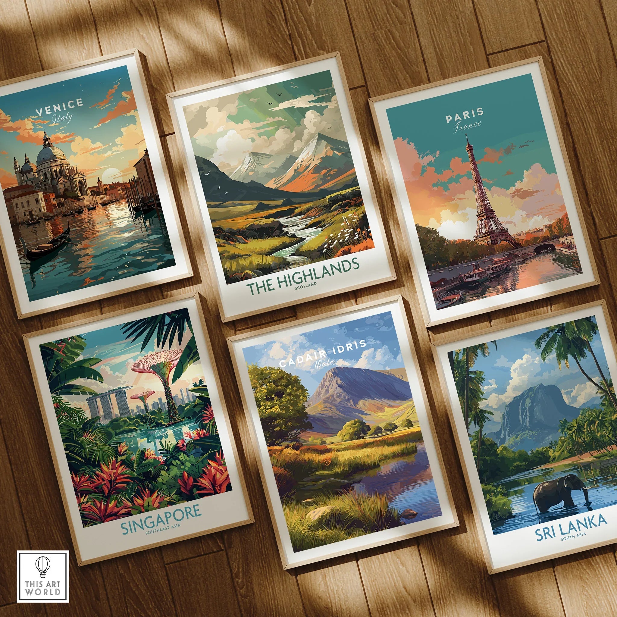 Set of six framed travel art prints featuring Venice, Paris, Singapore, The Highlands, Cadair Idris, and Sri Lanka on a wooden floor.