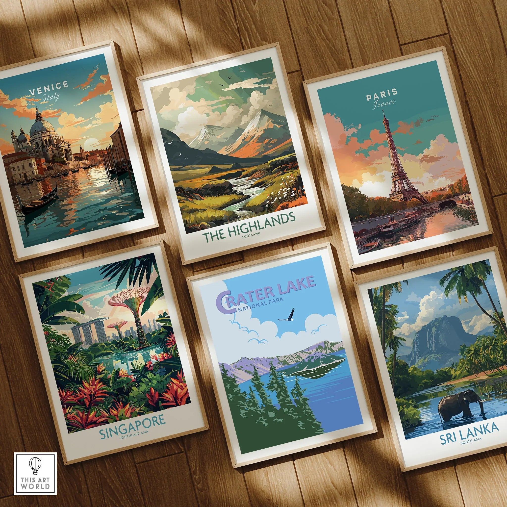 Set of six framed travel and national park art prints on wooden floor, featuring Venice, Paris, The Highlands, Singapore, Crater Lake, and Sri Lanka.