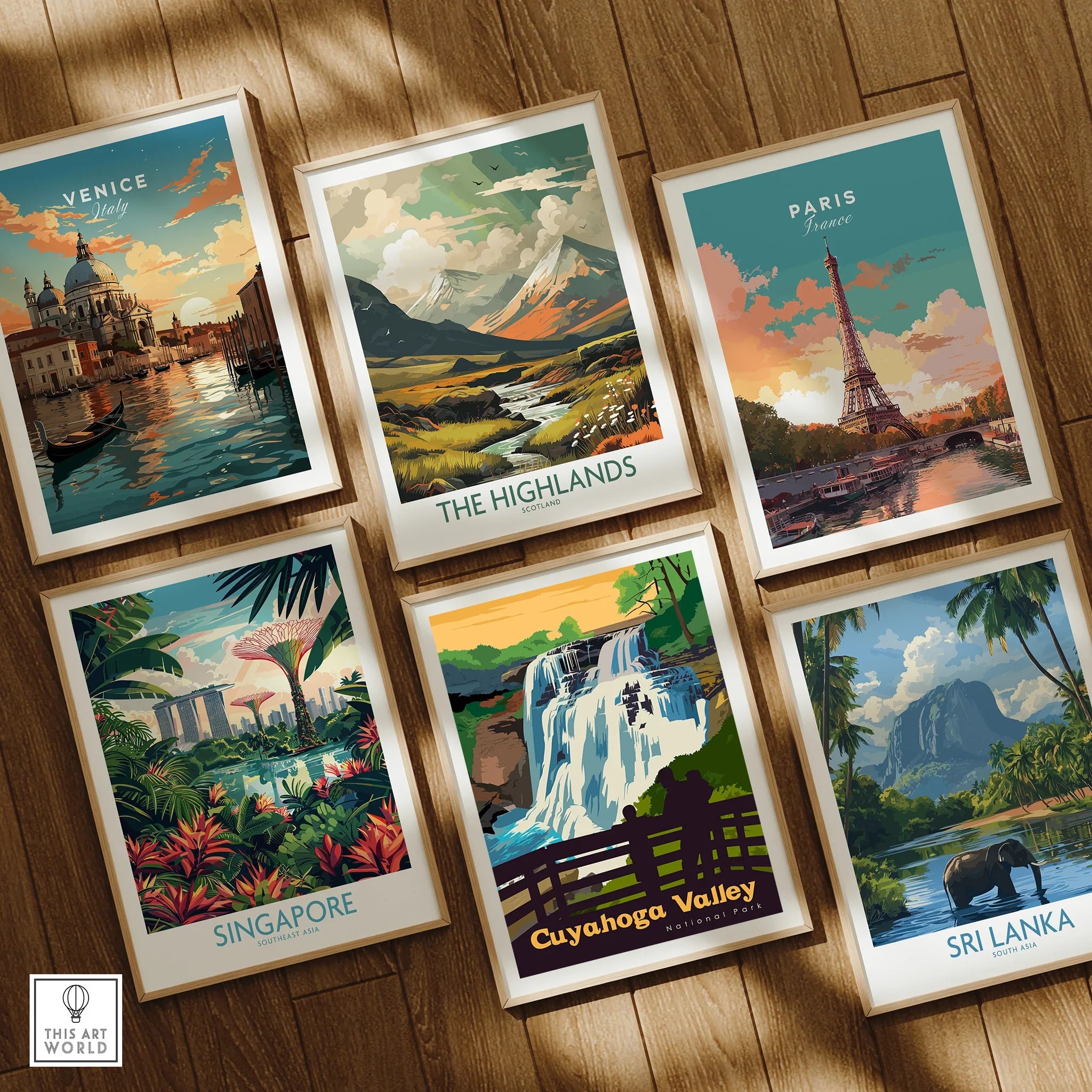 Set of six framed travel art prints featuring Venice, Paris, Highlands, Singapore, Cuyahoga Valley, and Sri Lanka, displayed on wooden floor.