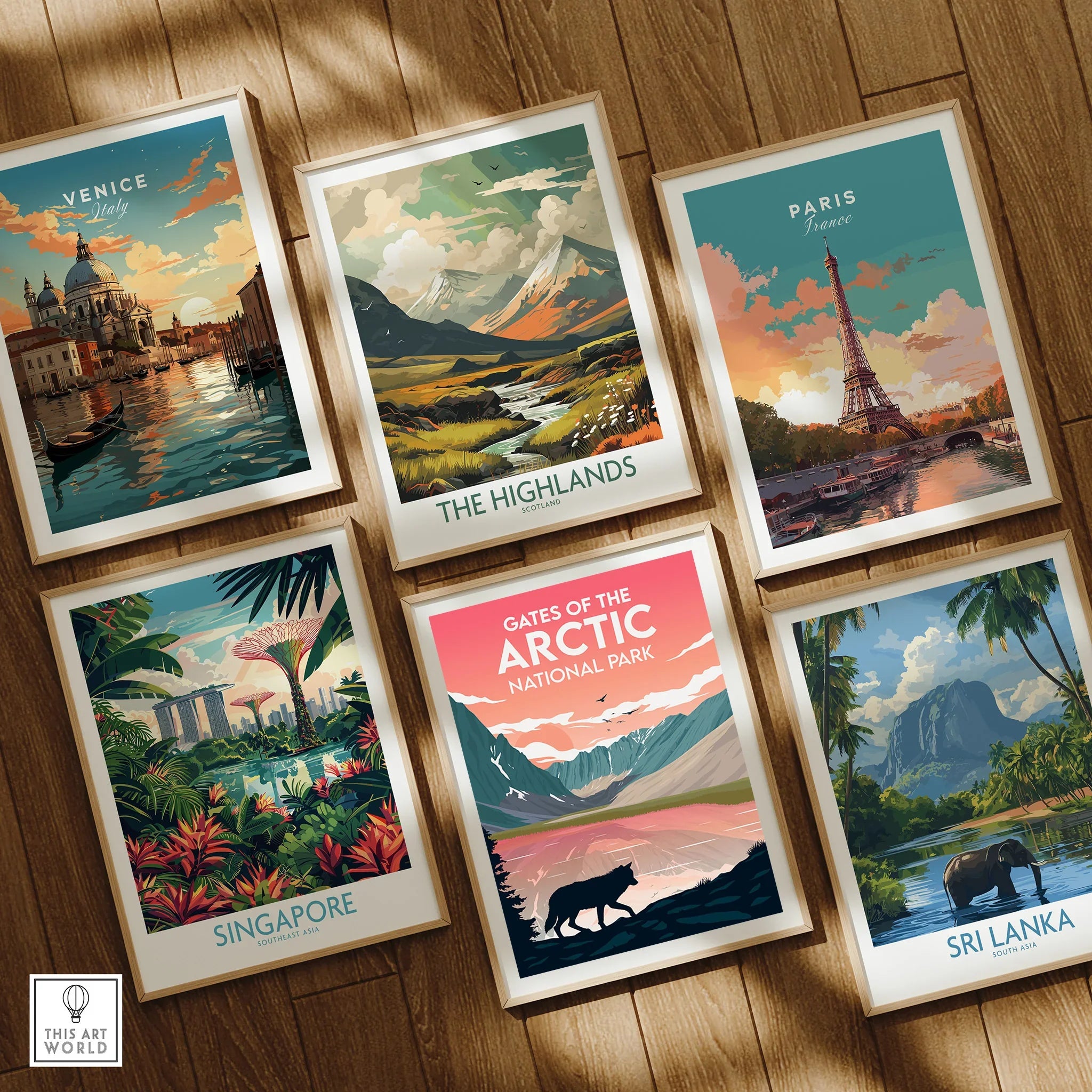 Set of six framed travel posters featuring Venice, Paris, Singapore, Scotland Highlands, Gates of the Arctic National Park, and Sri Lanka on a wooden floor.