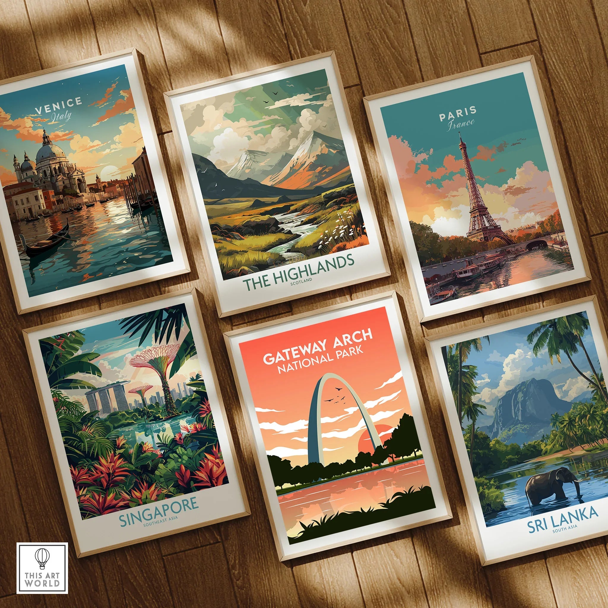Set of six framed travel posters featuring Venice, Paris, Sri Lanka, Singapore, The Highlands, and Gateway Arch on a wooden floor