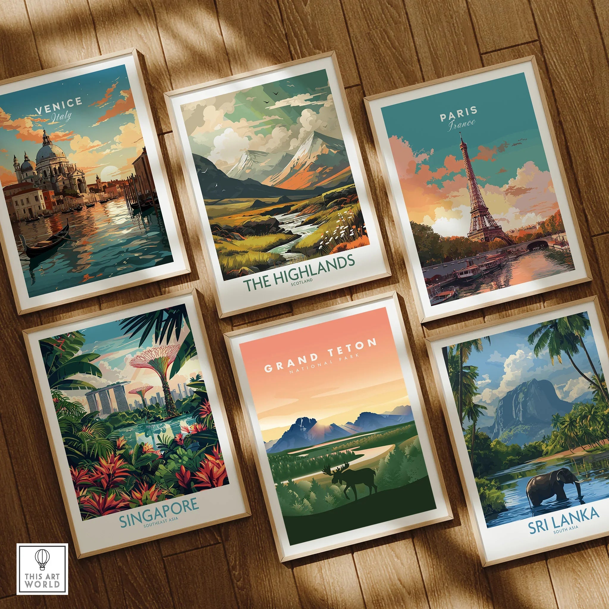 Set of six framed travel art prints featuring Venice, The Highlands, Paris, Singapore, Grand Teton, and Sri Lanka, displayed on a wooden floor.