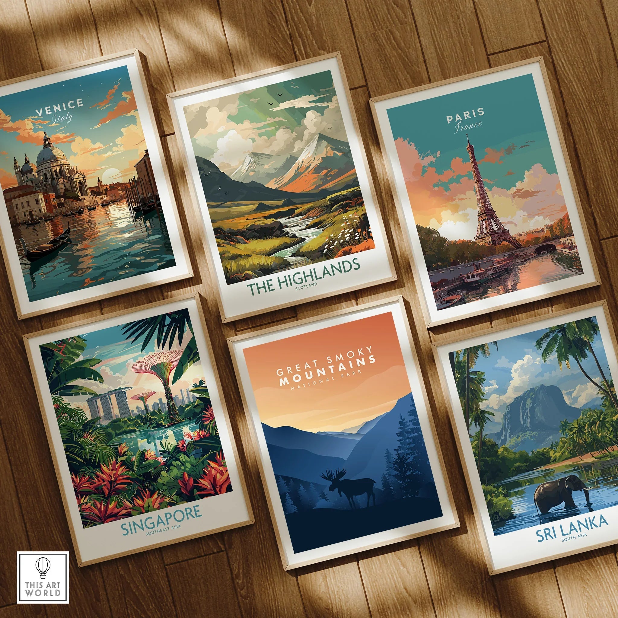 Set of six framed travel posters featuring Venice, Paris, Highlands, Singapore, Sri Lanka, Great Smoky Mountains on a wooden floor.