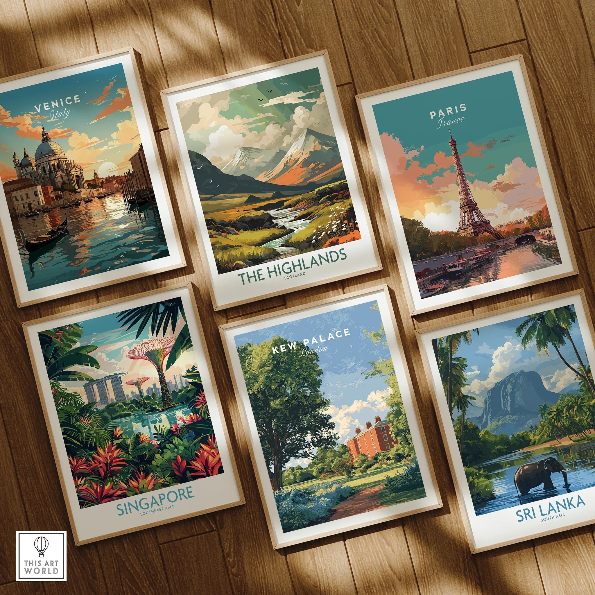 Set of six travel art prints in natural wood frames on a wooden floor featuring Venice, Paris, the Highlands, Singapore, Kew Palace, and Sri Lanka landscapes.