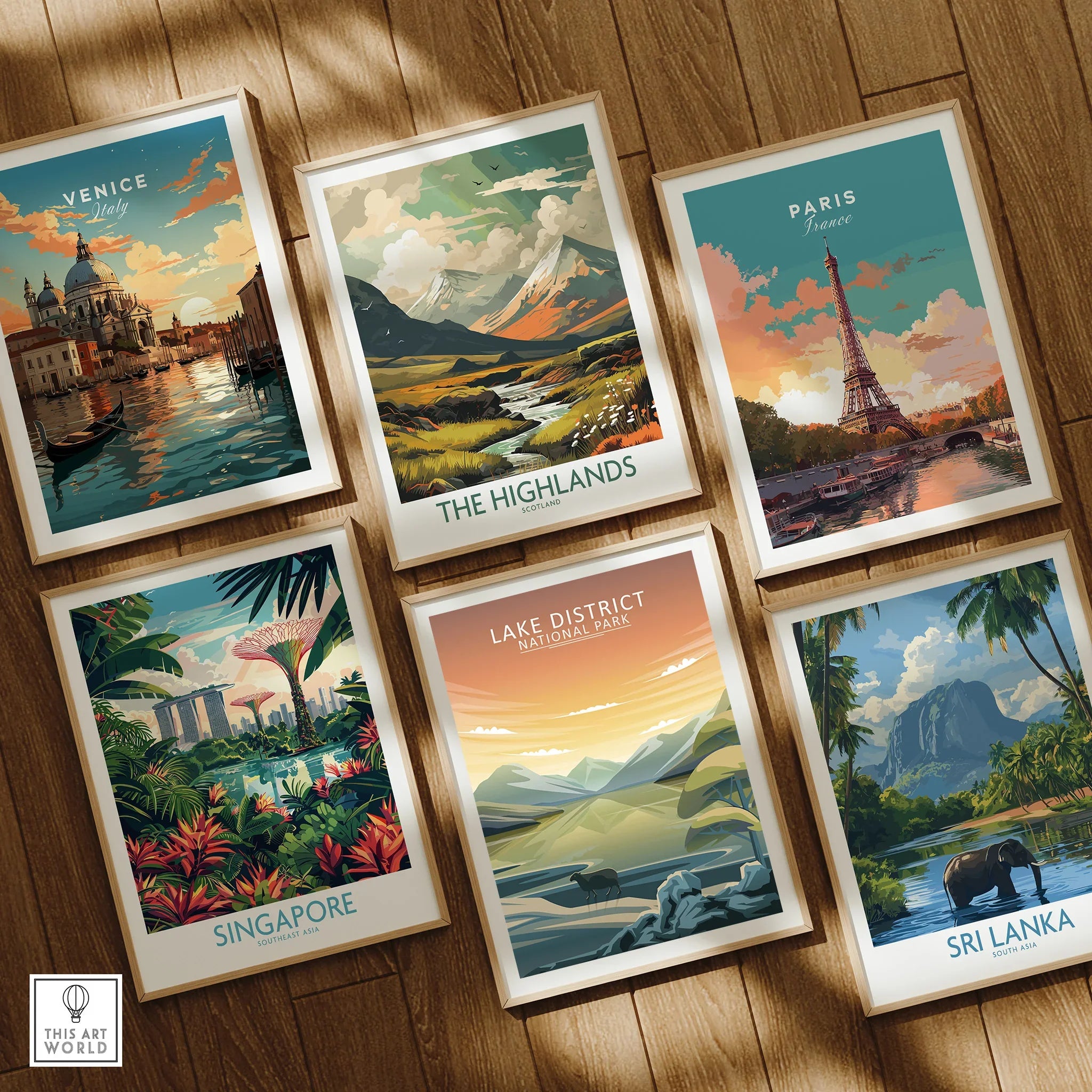 Set of six framed travel art prints featuring Venice, Paris, Highlands, Singapore, Lake District, and Sri Lanka on wooden floor.