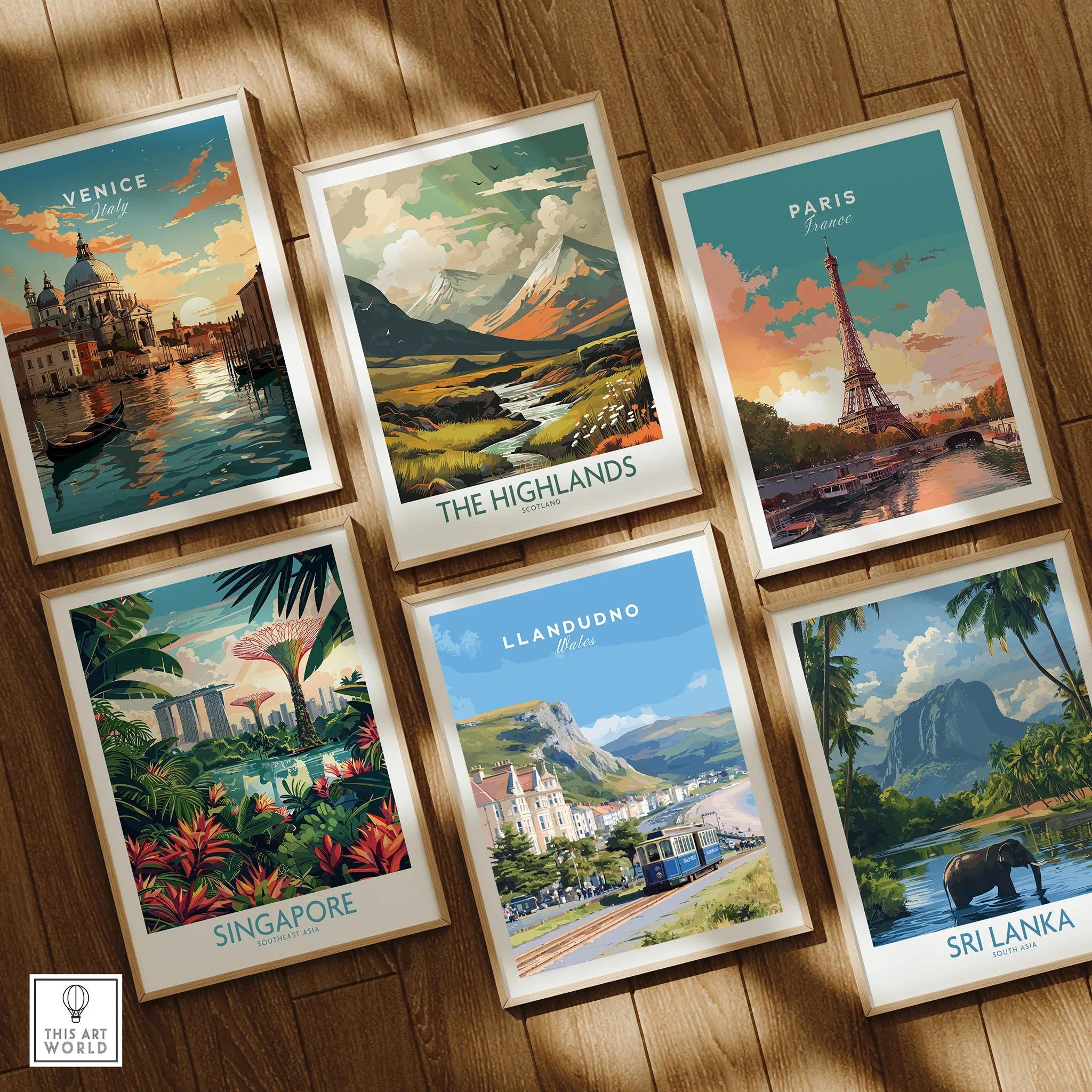 Set of six framed travel art prints featuring Venice, Paris, The Highlands, Singapore, Llandudno, and Sri Lanka on a wooden floor.