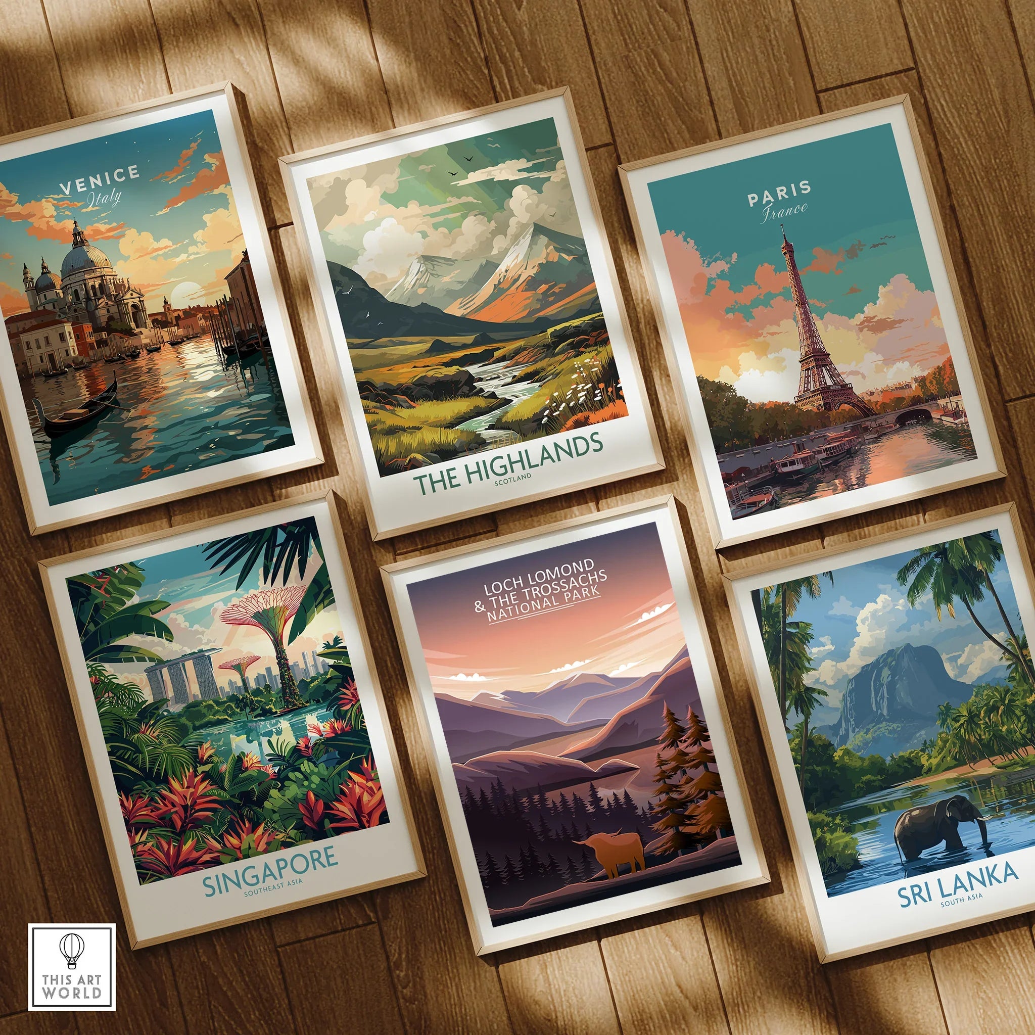 Set of six framed travel posters featuring Venice, Paris, Sri Lanka, Singapore, the Highlands, and Loch Lomond, displayed on a wooden floor.