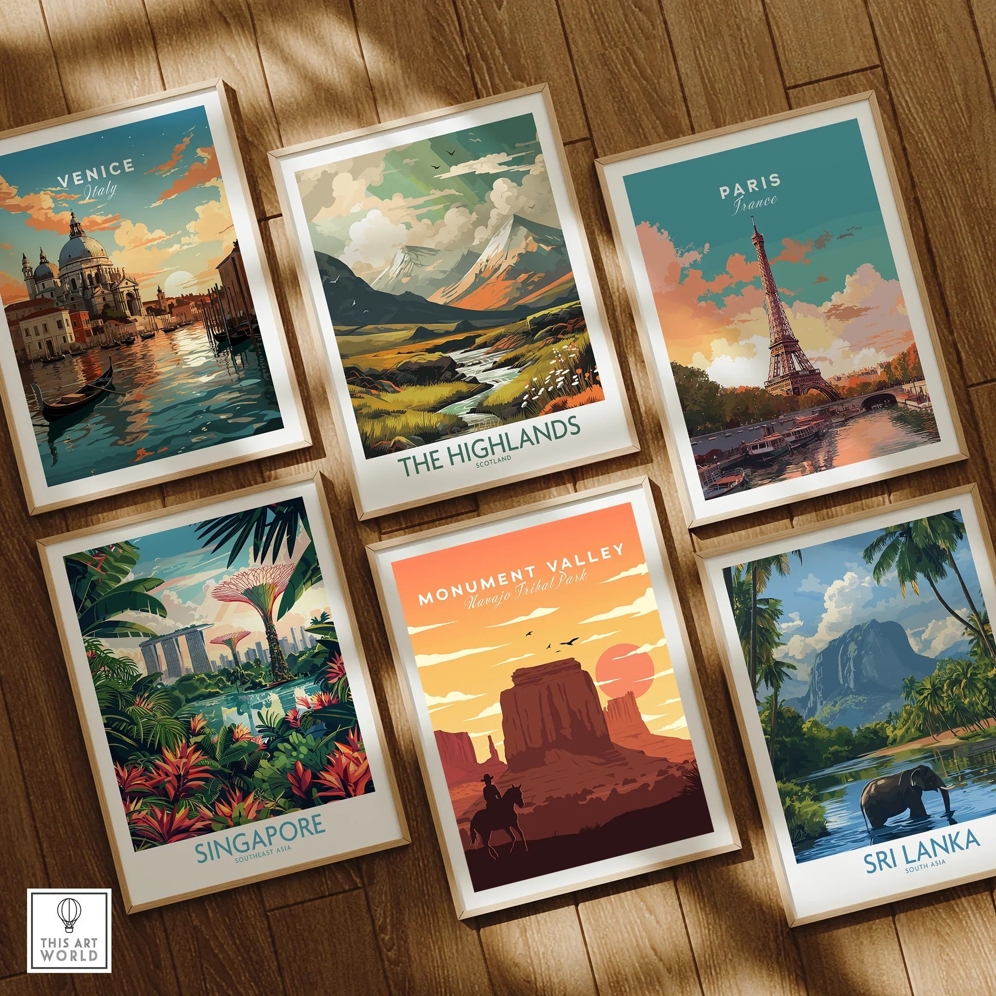 Set of six framed travel posters on wooden floor featuring Venice, Paris, Monument Valley, Singapore, The Highlands, and Sri Lanka.