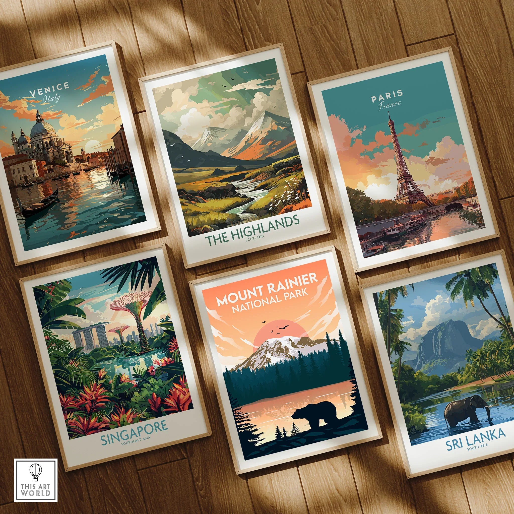 Set of six framed travel posters featuring Venice, Paris, Mount Rainier, and scenic landscapes on a wooden floor.