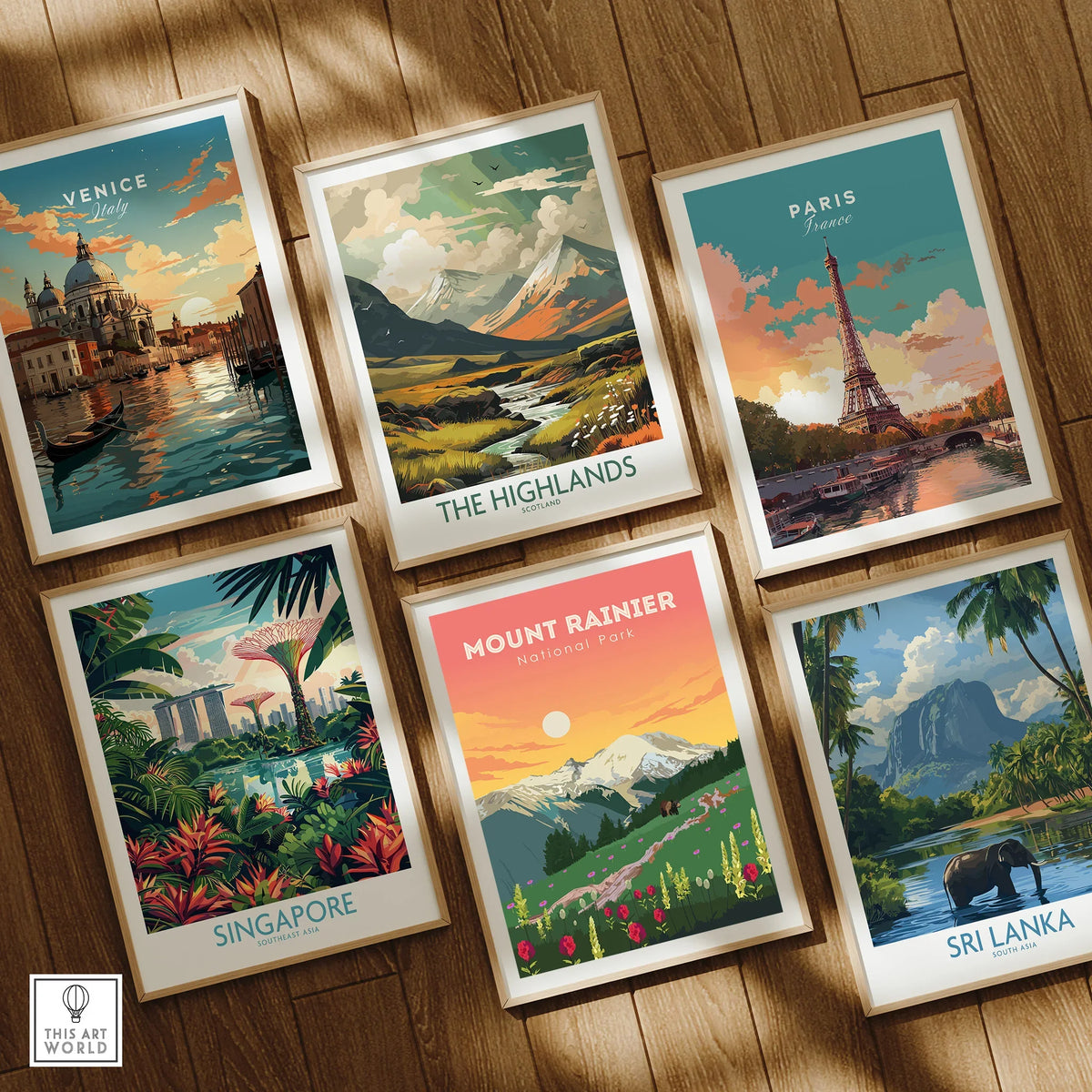 Set of six framed travel and national park art prints on wooden floor, featuring Venice, Paris, Mount Rainier, The Highlands, Singapore, and Sri Lanka.