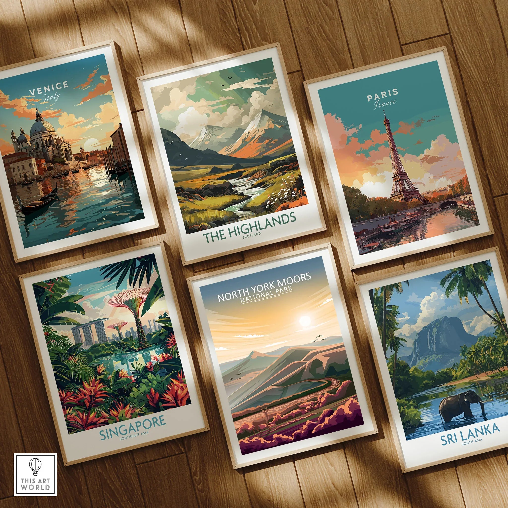 Set of six framed travel posters featuring Venice, Paris, Singapore, Sri Lanka, The Highlands, and North York Moors, displayed on a wooden floor.