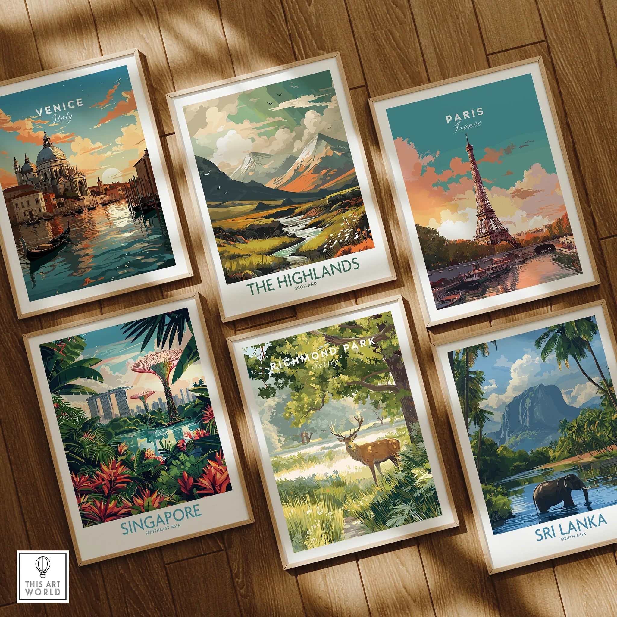 Set of six framed travel art prints on wooden floor, featuring Venice, The Highlands, Paris, Singapore, Richmond Park, and Sri Lanka landscapes.