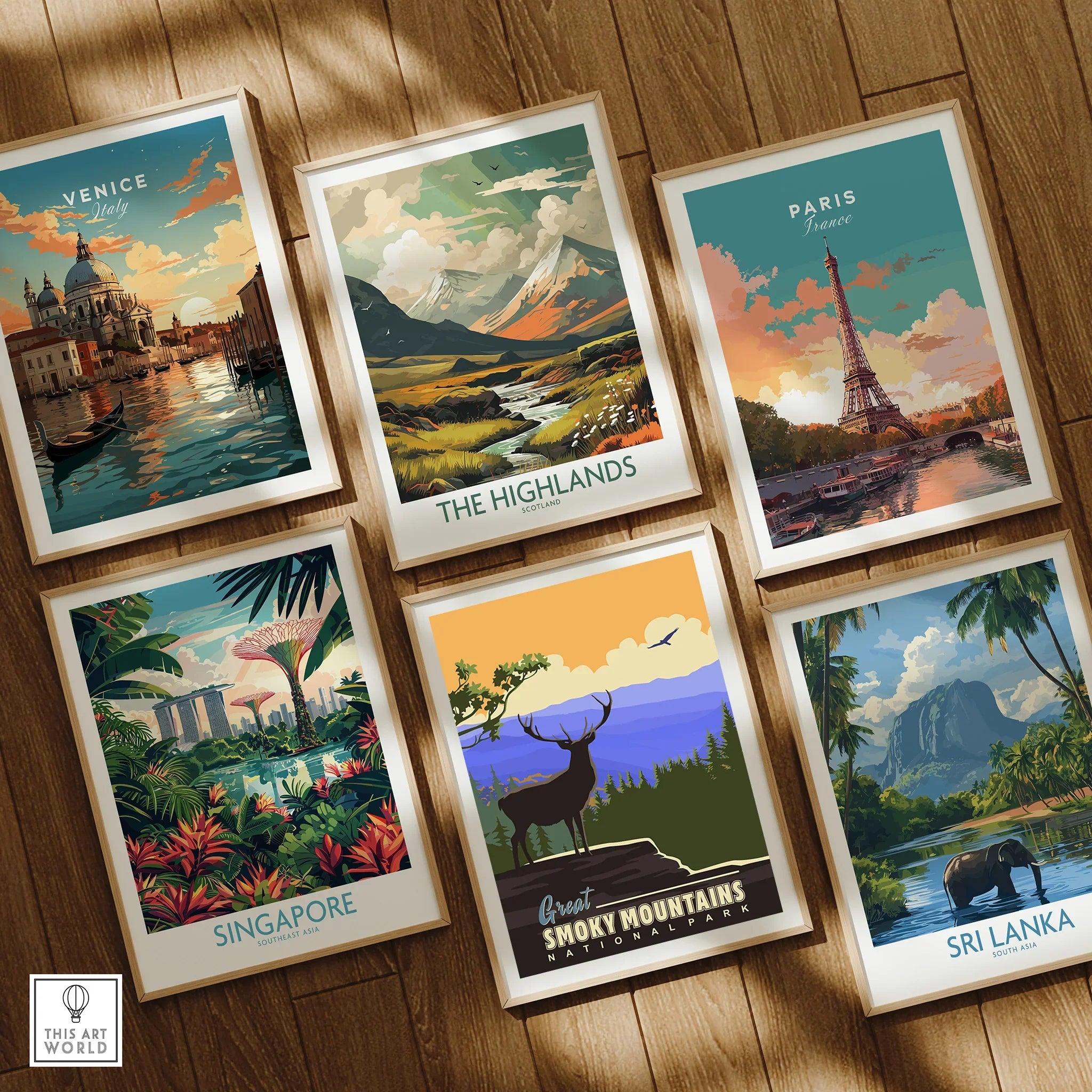 Set of six framed travel posters featuring Venice, Highlands, Paris, Singapore, Great Smoky Mountains, and Sri Lanka on a wooden floor.