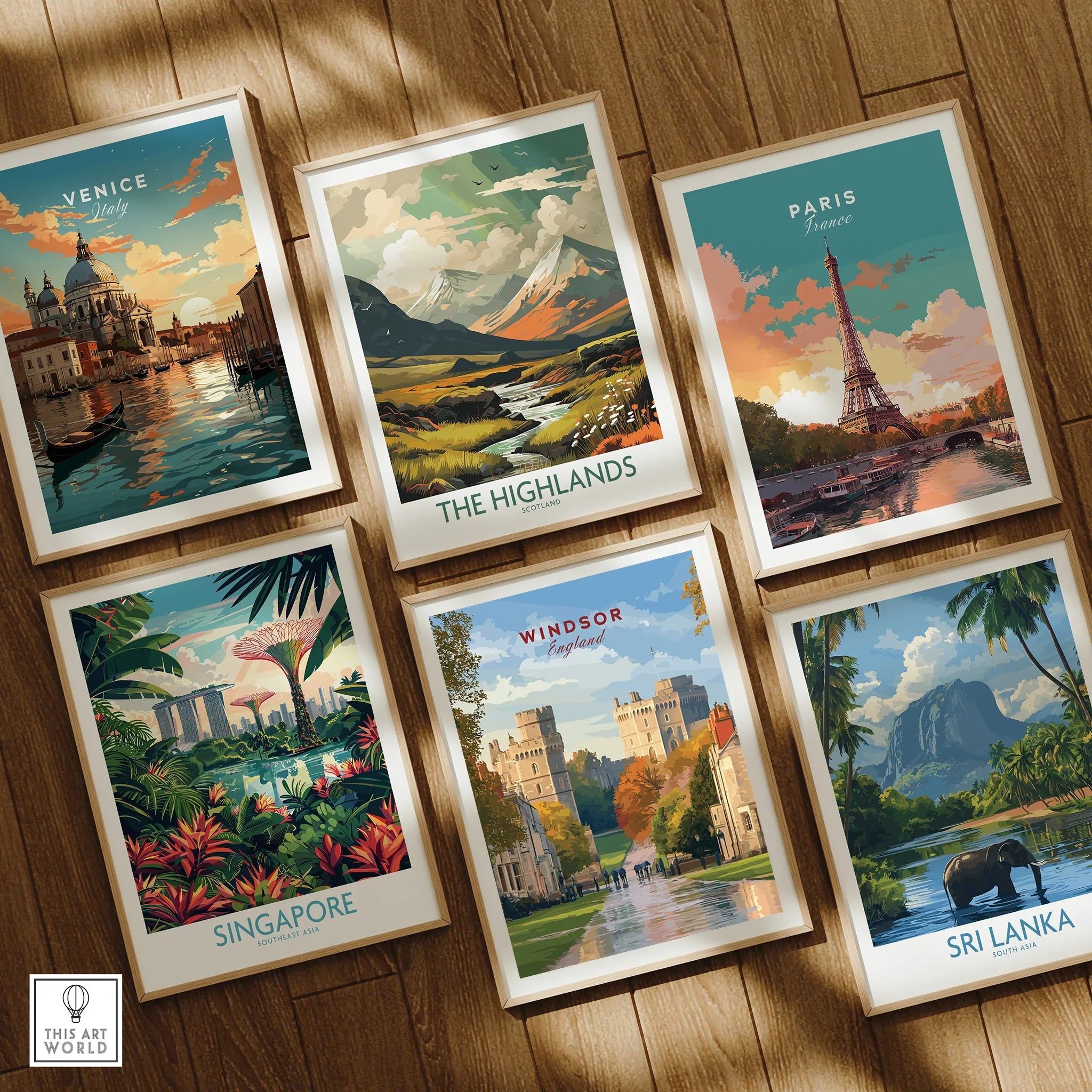 Set of six framed travel art prints on wooden floor, featuring Venice, Paris, Highlands, Singapore, Windsor, Sri Lanka.