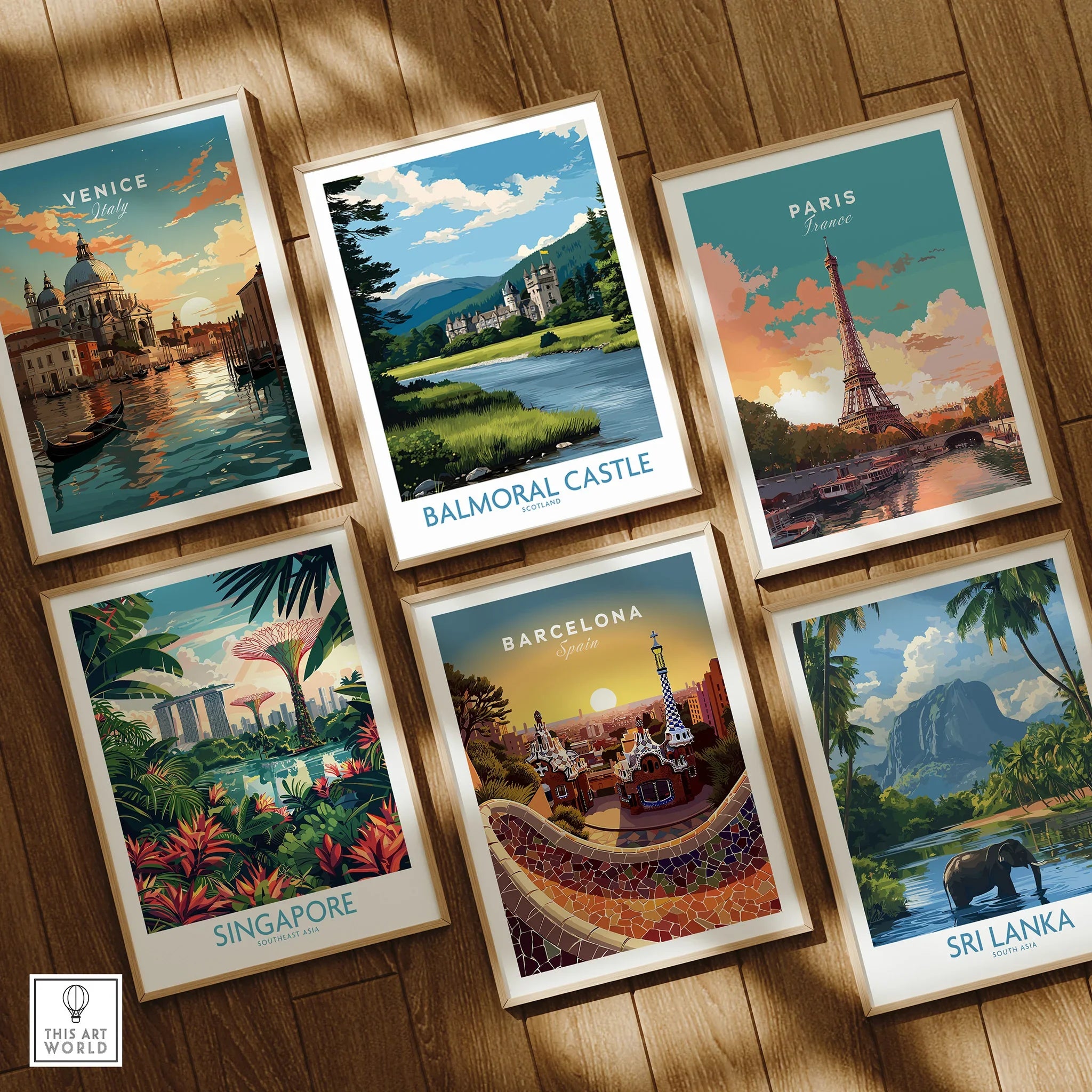 Set of six framed travel art prints featuring Venice, Balmoral Castle, Paris, Singapore, Barcelona, and Sri Lanka on a wooden floor.
