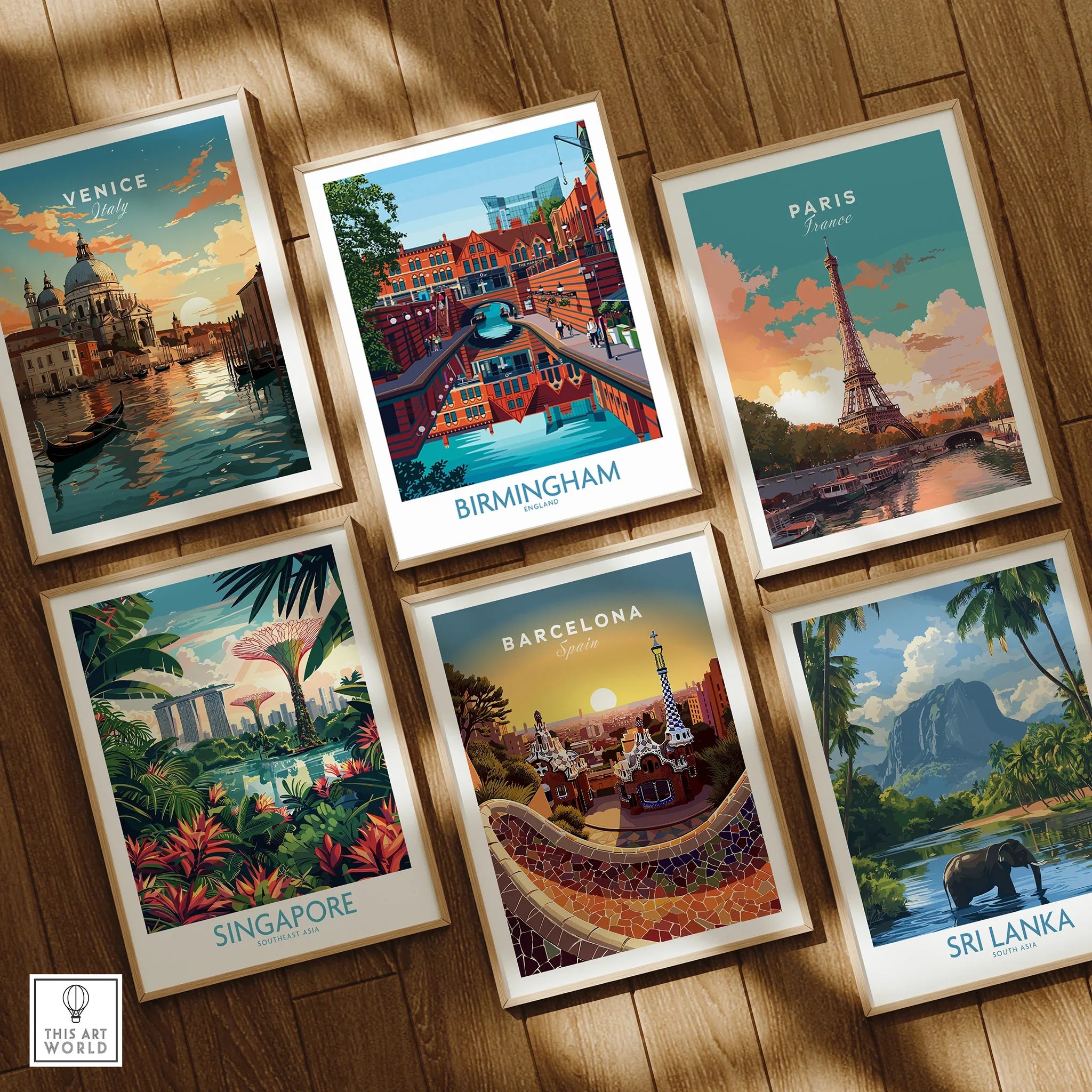 Set of six framed travel art prints featuring Venice, Birmingham, Paris, Singapore, Barcelona, and Sri Lanka, displayed on a wooden floor.
