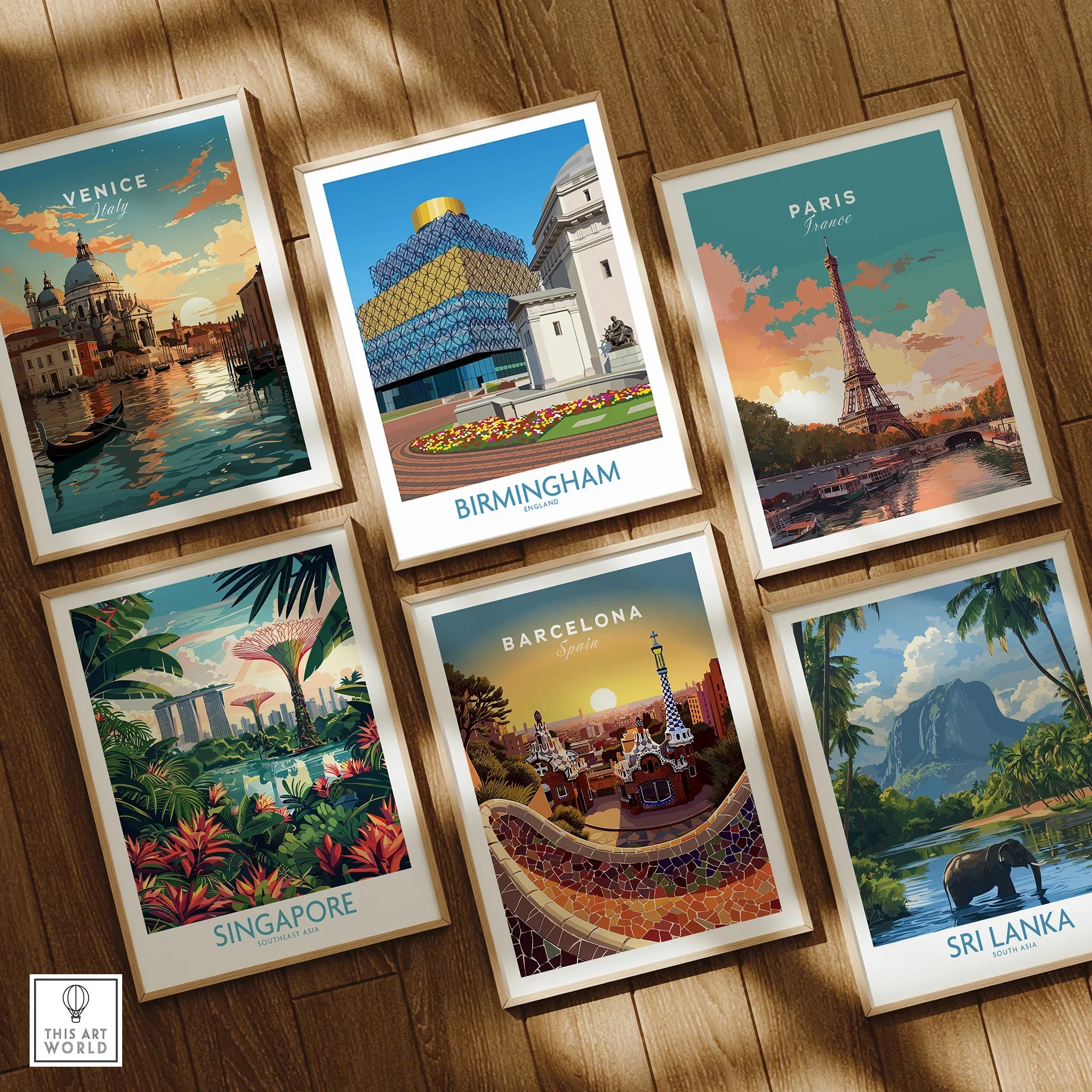 Set of six framed travel posters featuring Venice, Birmingham, Paris, Singapore, Barcelona, and Sri Lanka on a wooden floor.