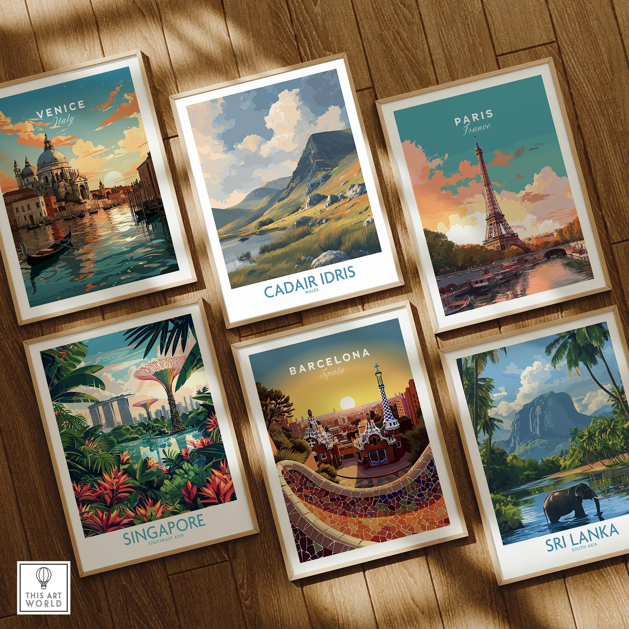 Set of six framed travel art prints, featuring Venice, Cadair Idris, Paris, Singapore, Barcelona, and Sri Lanka, on a wooden floor.