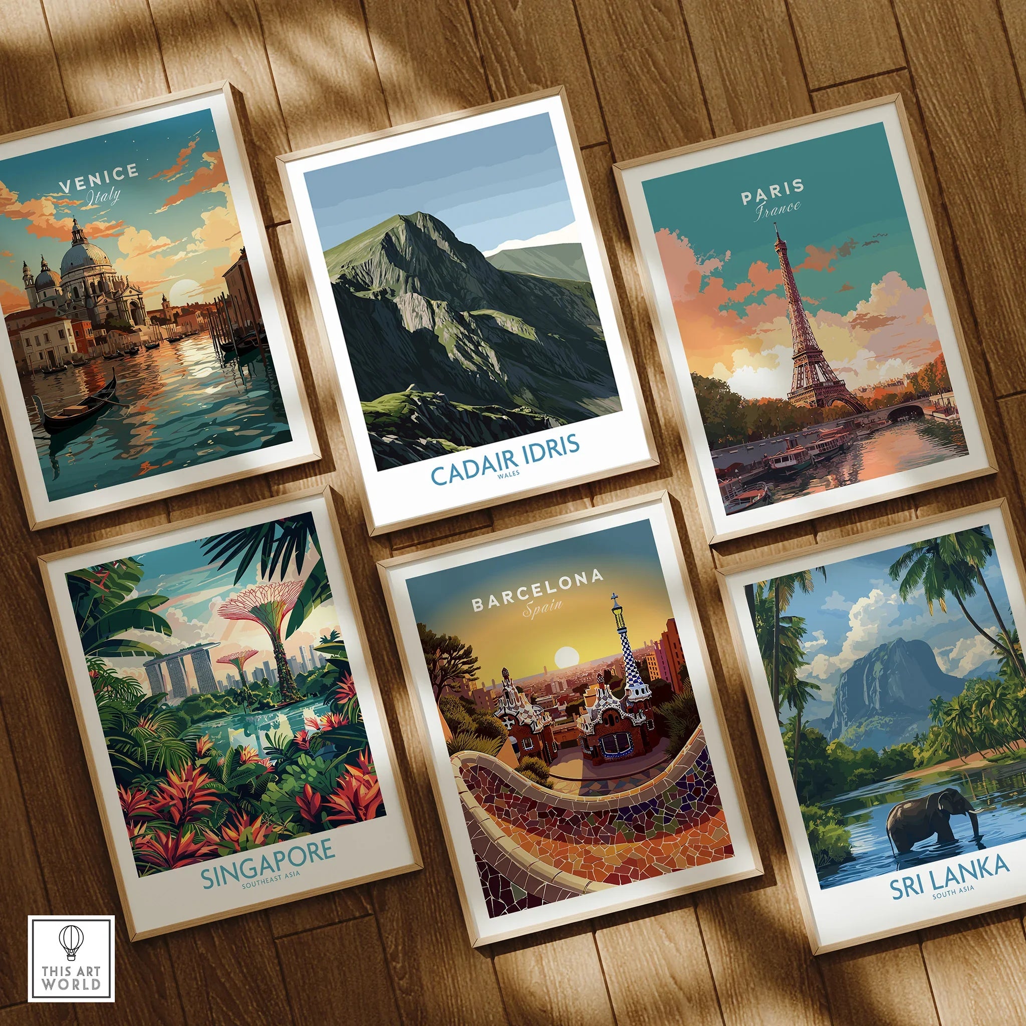 Set of six framed travel posters for Venice, Cadair Idris, Paris, Singapore, Barcelona, and Sri Lanka on a wooden floor