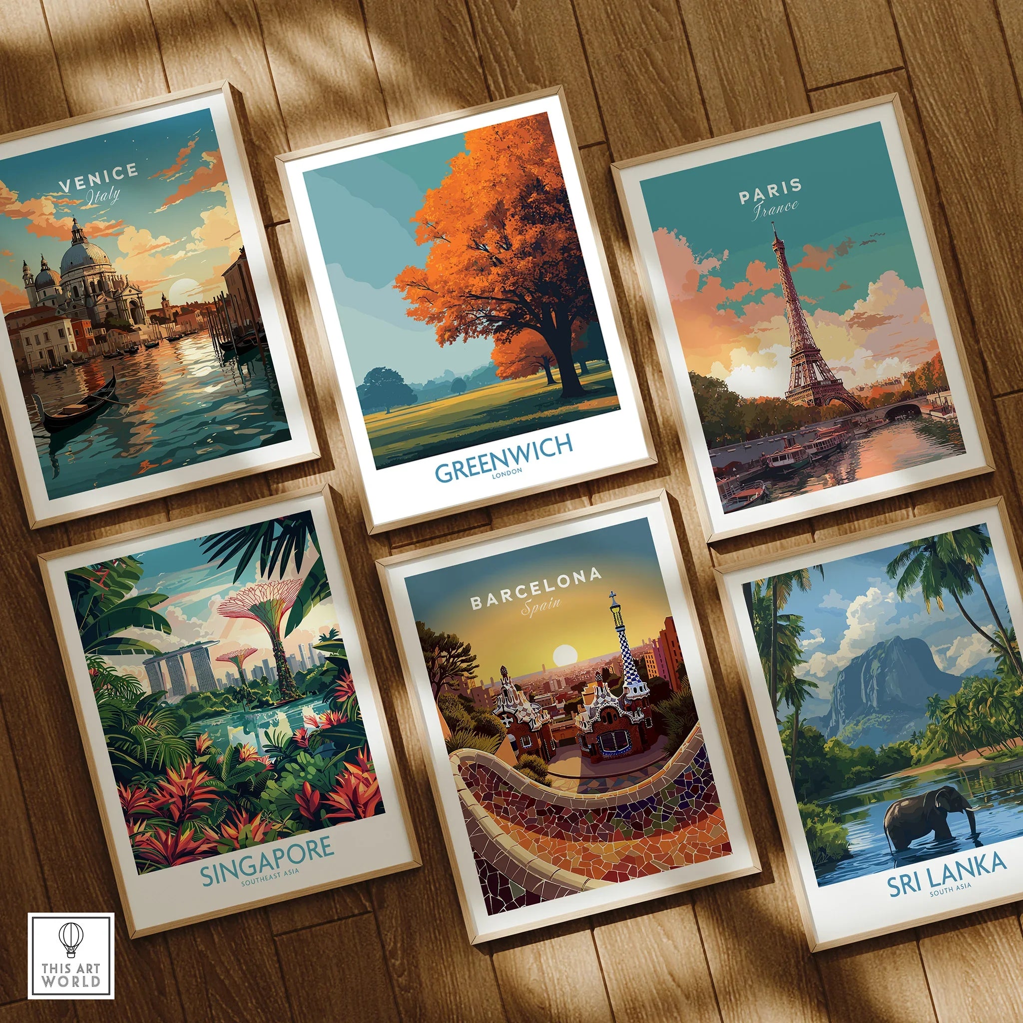 Set of six travel poster art prints featuring Venice, Greenwich, Paris, Singapore, Barcelona, and Sri Lanka in natural wood frames on wooden floor.