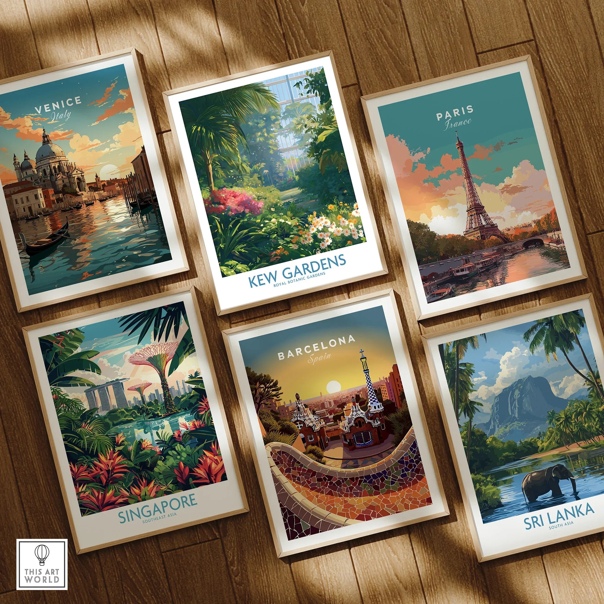 Set of six framed travel posters featuring Venice, Kew Gardens, Paris, Singapore, Barcelona, and Sri Lanka, laid out on a wooden floor.