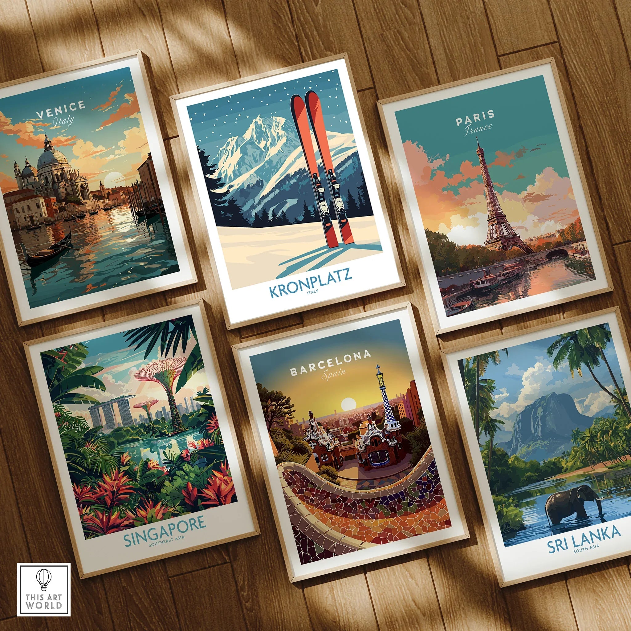 Set of six framed travel posters featuring Venice, Kronplatz, Paris, Singapore, Barcelona, and Sri Lanka on a wooden floor.
