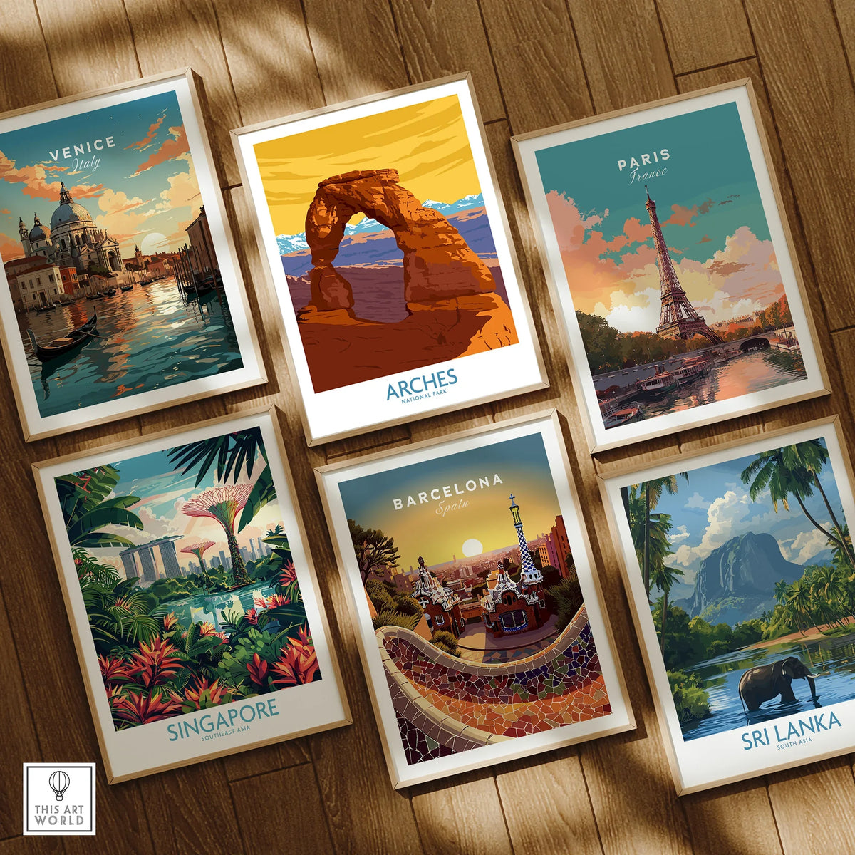 Set of six framed travel posters featuring Venice, Arches National Park, Paris, Singapore, Barcelona, and Sri Lanka, displayed on a wooden floor.
