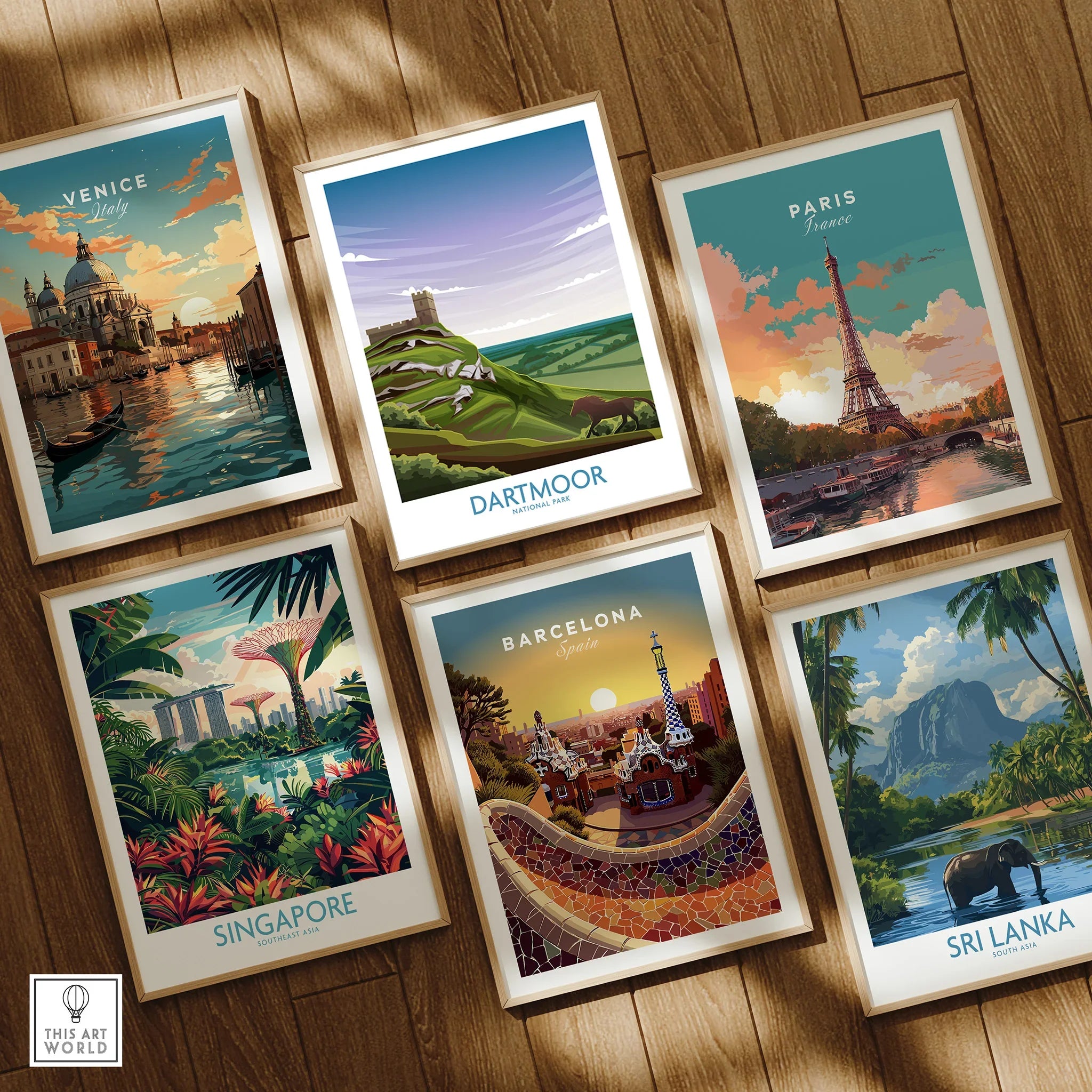 Set of six framed travel art prints featuring Venice, Paris, Dartmoor, Singapore, Barcelona, Sri Lanka on wooden floor.