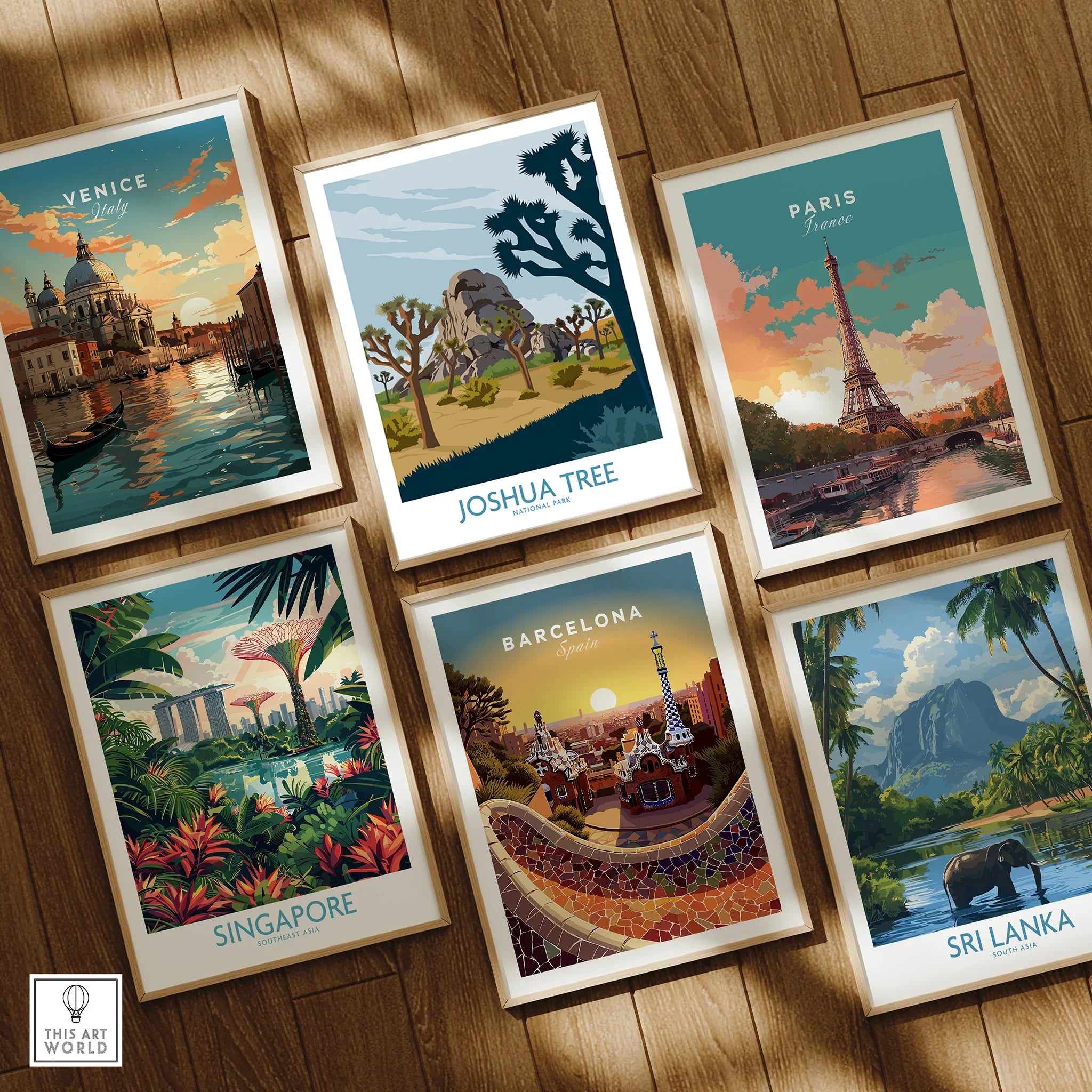 Set of six framed travel posters featuring Venice, Joshua Tree, Paris, Singapore, Barcelona, Sri Lanka on wooden floor.